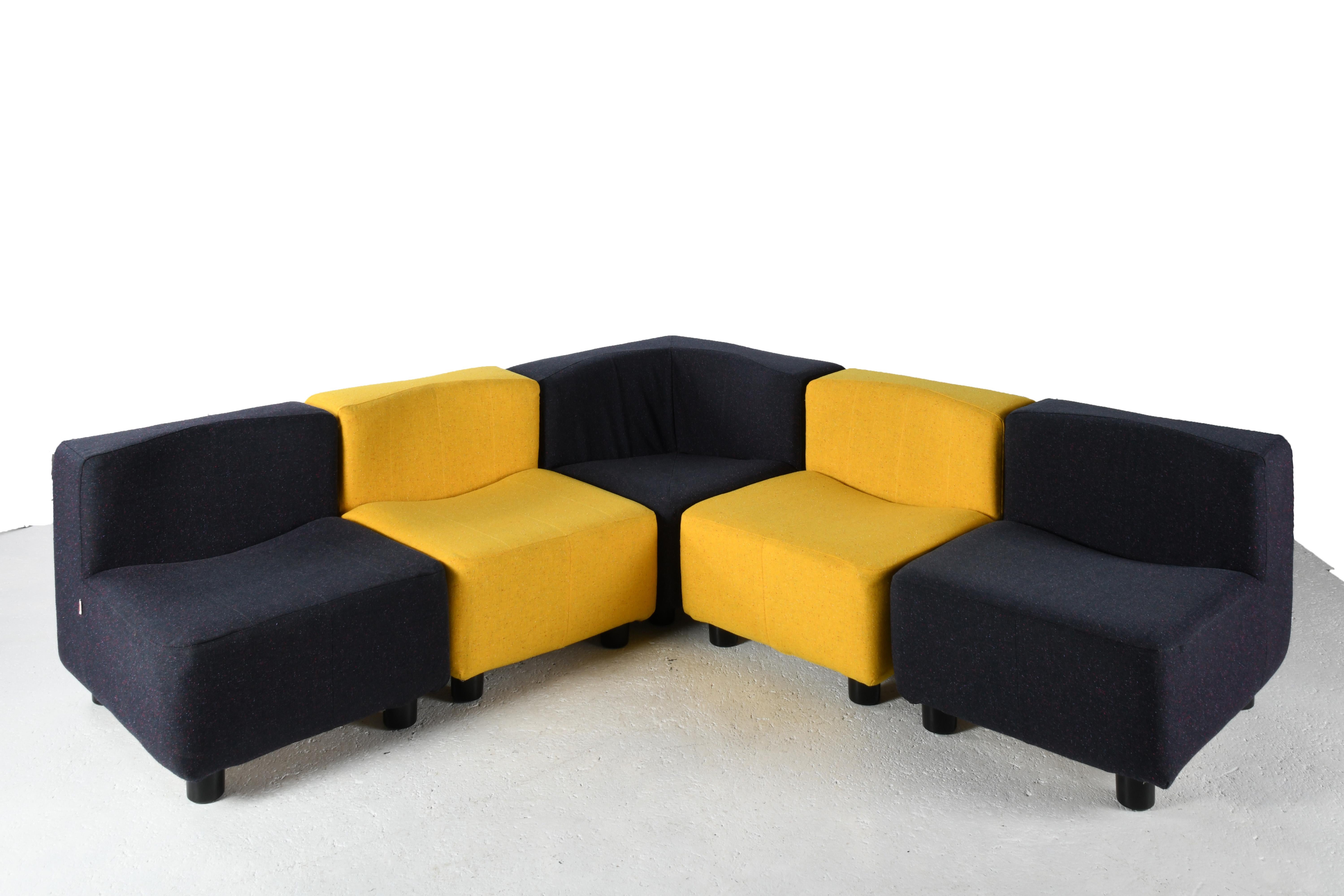 Suite of five designer armchairs in the style of Tito Agnoli and his 9000 (Novemila) model, published by Arfa. Metal frame and foam upholstered in fabric, black plastic legs. One corner seat and four straight seats in two colours, yellow and navy
