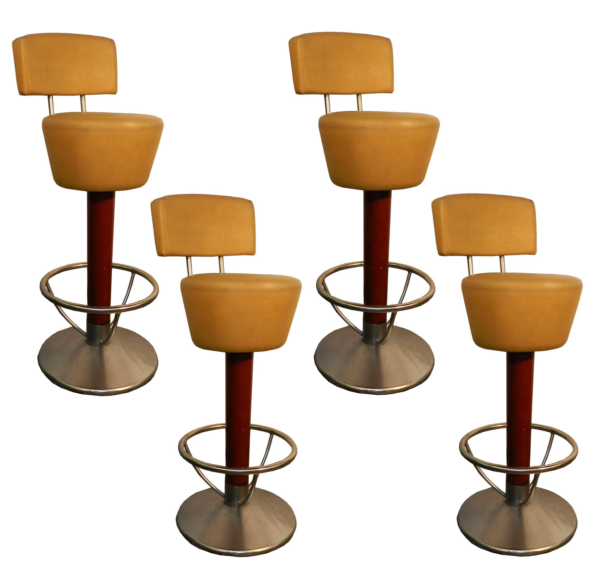 Suite de quatre tabourets de bar en hêtre teinté, acier et similicuir, vers 1970