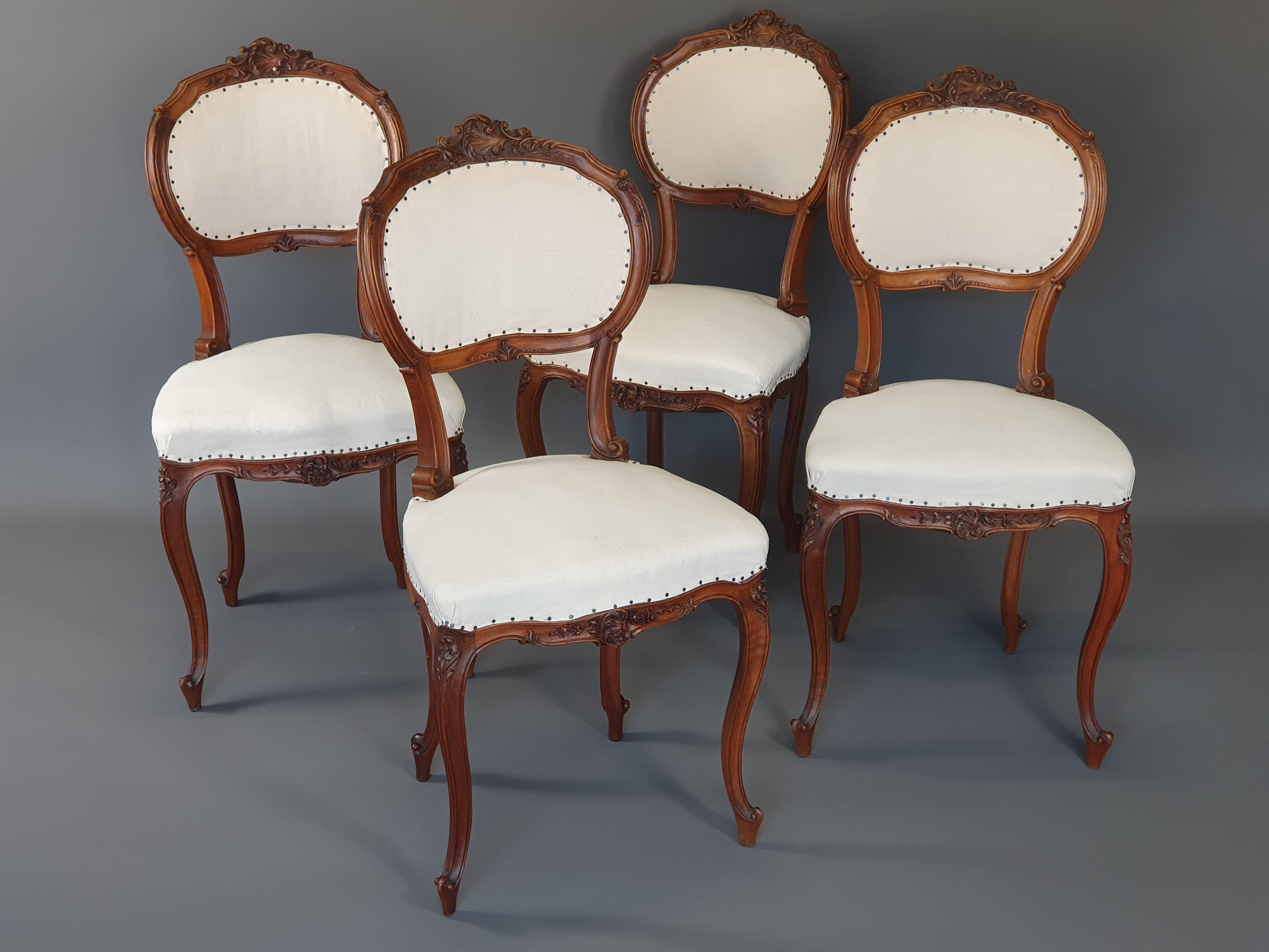 Charming suite of four Louis XV style chairs in solid walnut richly carved with rock-inspired motifs.
Linen and cotton fabric upholstery (so-called Métis fabric of old manufacture but new, never used).

Firm seats in perfect condition.

Very