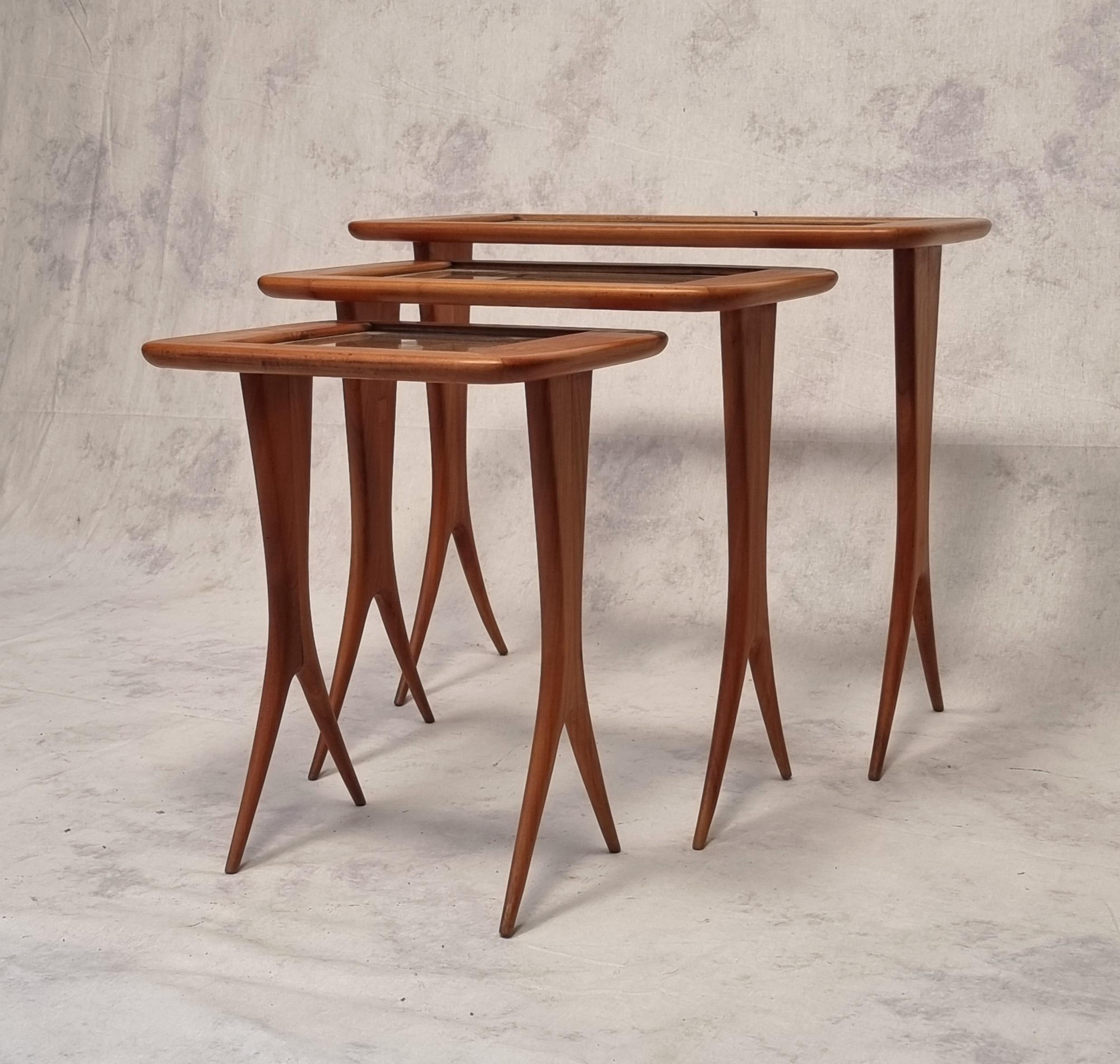 Superb and rare set of three nesting tables by the French designer Raphaël Raffel dit Raffel. These three tables have a rectangular glass top and rest on an atypical base whose streamlined shape splits into two. This set is a beautiful