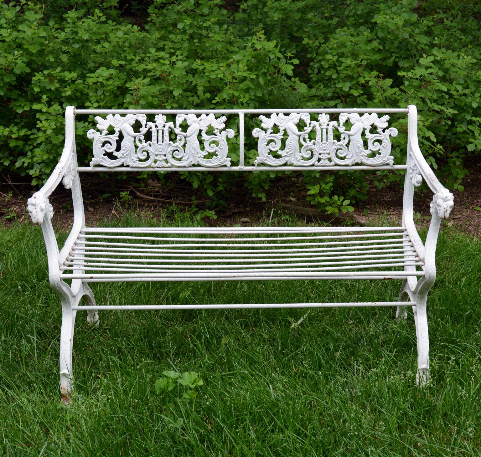 A suite of cast-iron seating furniture comprised of a settee and two armchairs, after an 1825 design produced for the Potsdam Parks in Berlin by Prussian architect, Karl Friedrich Schinkel (1781-1841), the back panels of the settee ornamented with