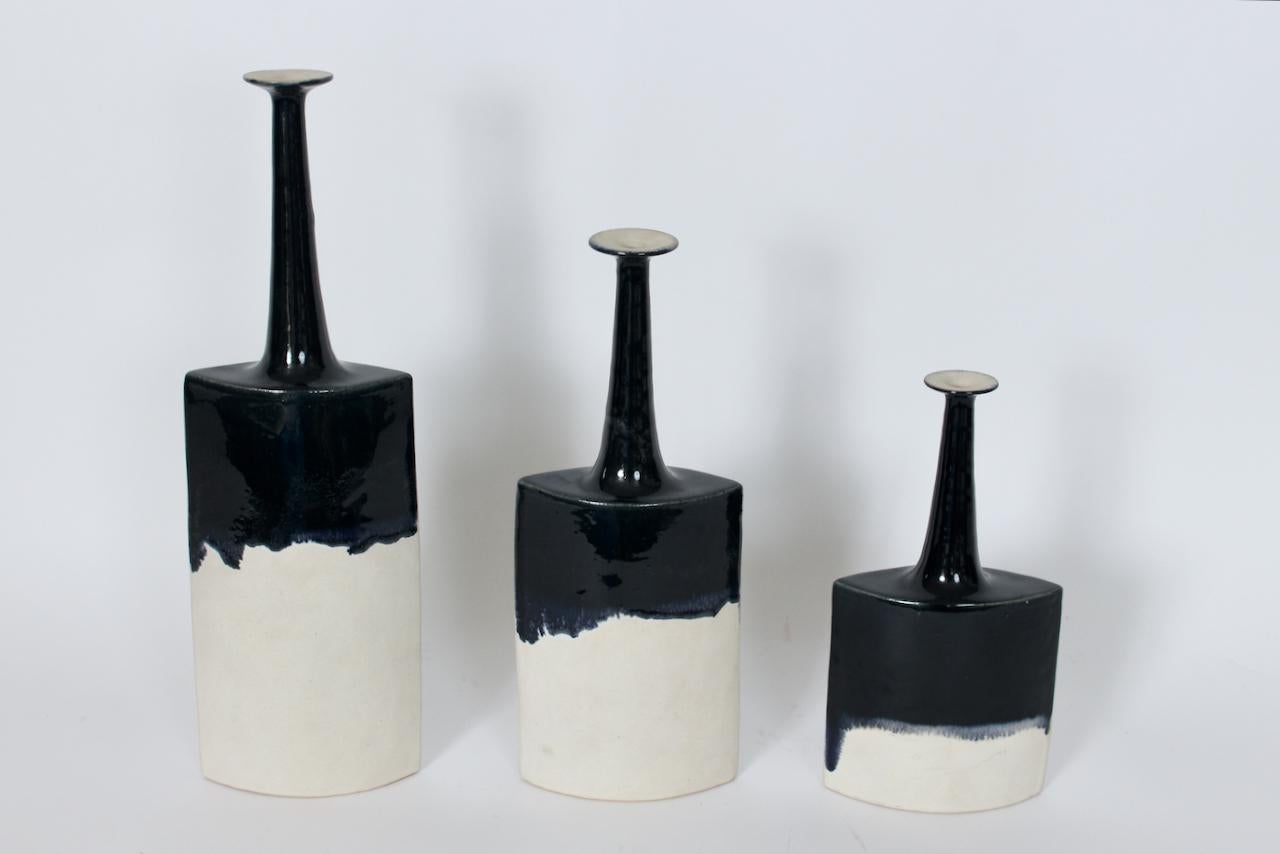 Set de 3 Bruno Gambone  Vases-bouteilles en céramique émaillée blanc chaud.  Whiting, 3 formes de bouteilles en céramique blanc cassé mat, de hauteur variable, avec des bouches évasées, une décoration bicolore peinte à la main, blanc chaud avec une