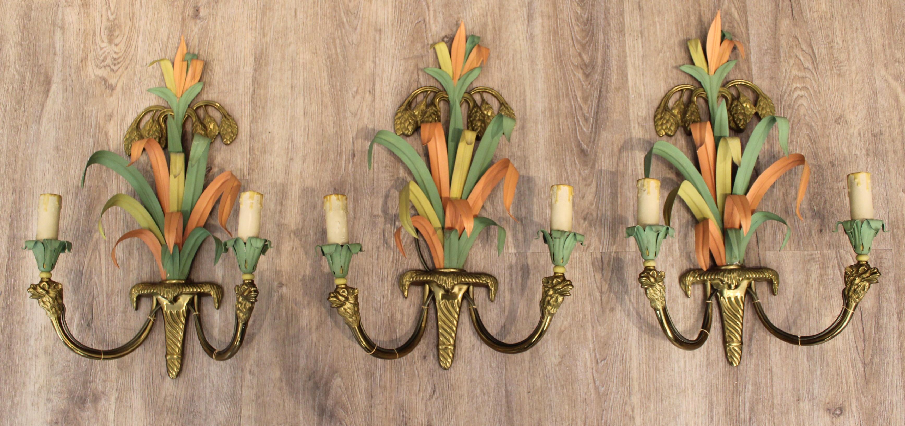 Suite of three wall lights from Maison Baguès,
Bronze and polychrome painted metal, palm leaf and camel head decoration,
France, circa 1950