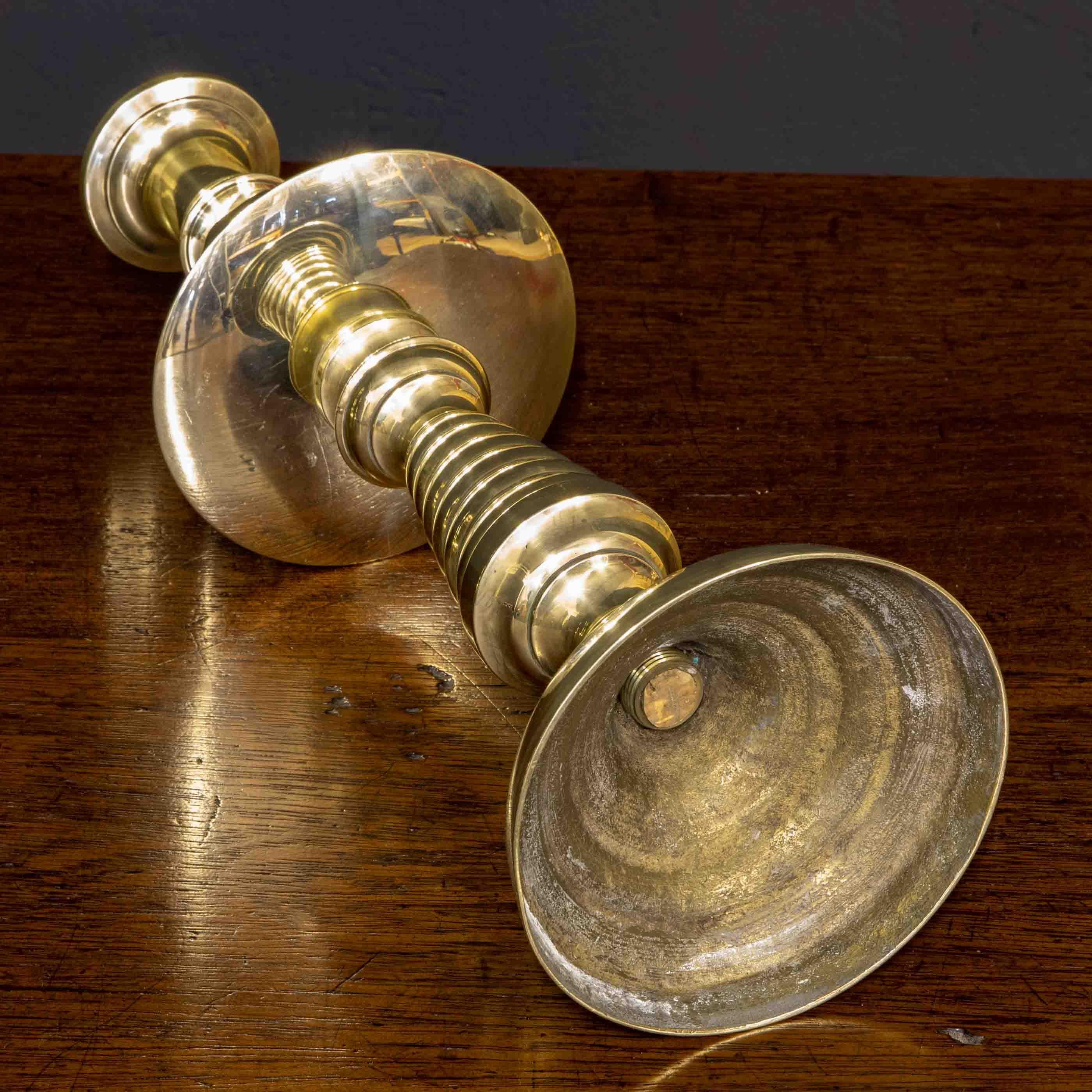An extremely rare suite of four Victorian brass candlesticks. The round bases give way to a beehive center section and then on to a 6 inch drip tray which in turn leads to a diamond faceted section and upper fixed candle sconce. In excellent