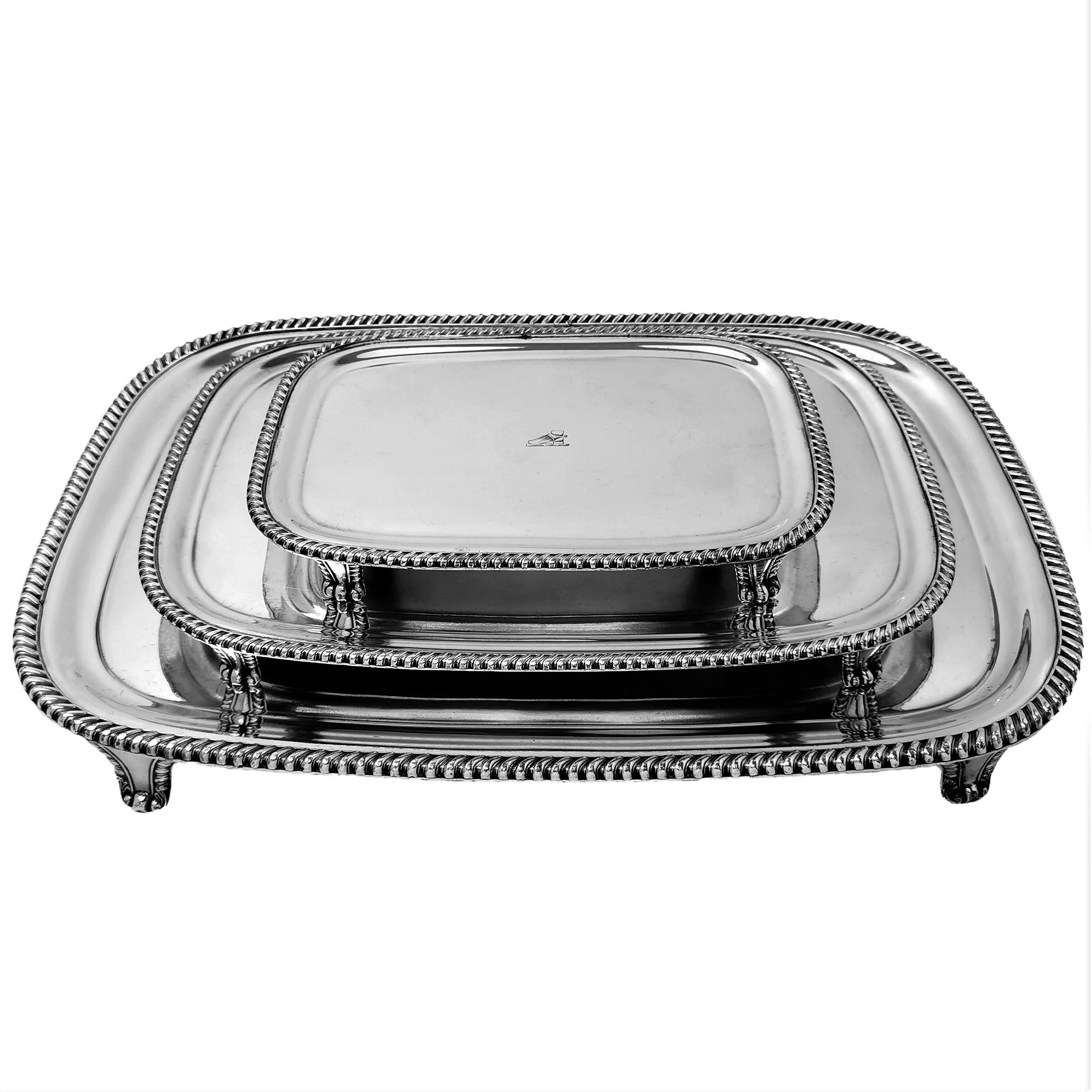 A set of Three Antique Old Sheffield silver plate Platters with curved rectangular forms. Each Tray has a classic gadroon edge border and each has a small crest engraved on the centre. Each Tray stands on four feet.

Made in Sheffield, England in