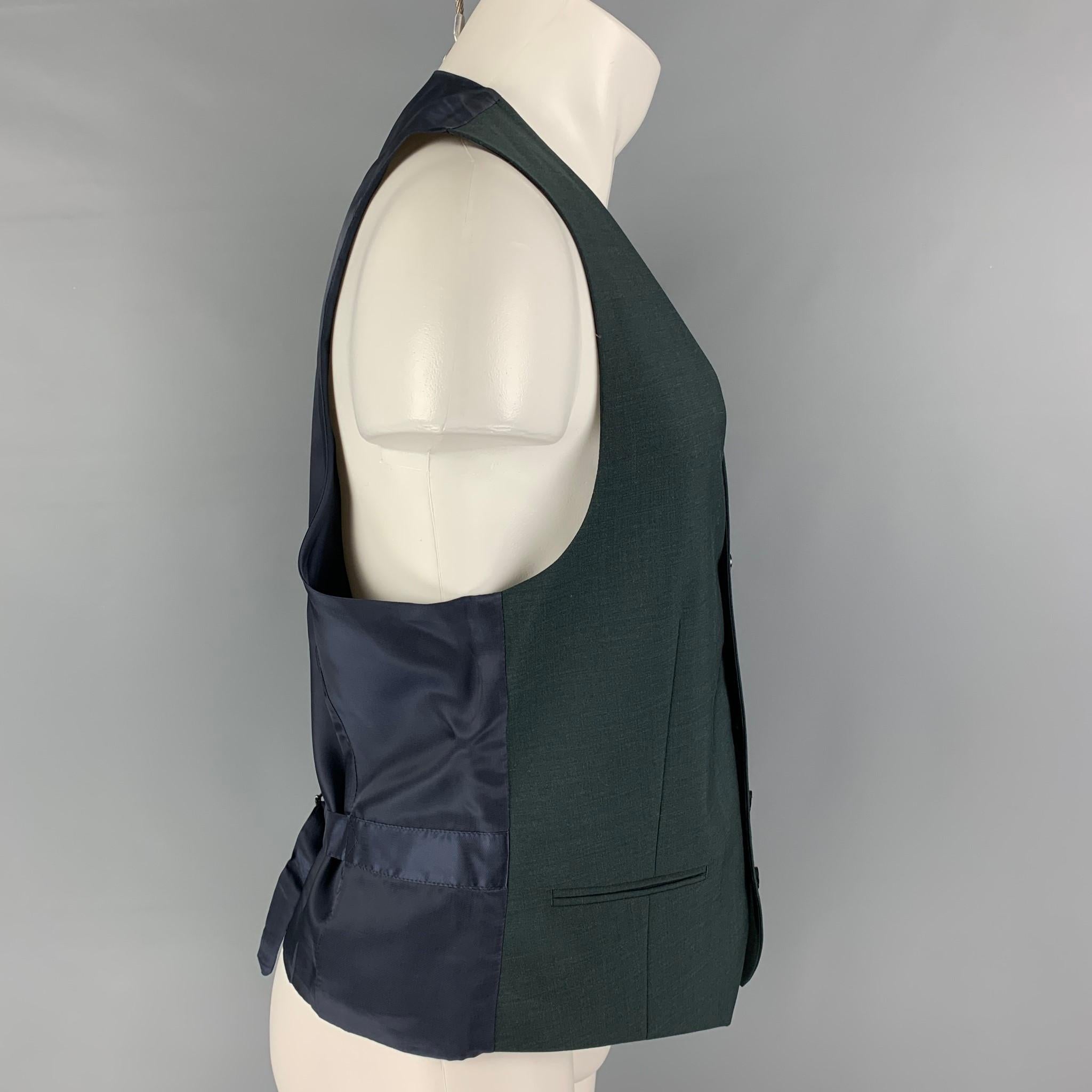 SUIT SUPPLY vest comes in a forest green wool featuring slit pockets, adjustable back strap, and a buttoned closure. 

Excellent Pre-Owned Condition.
Marked: 50

Measurements:

Shoulder: 14 in.
Chest: 40 in.
Length: 23 in.