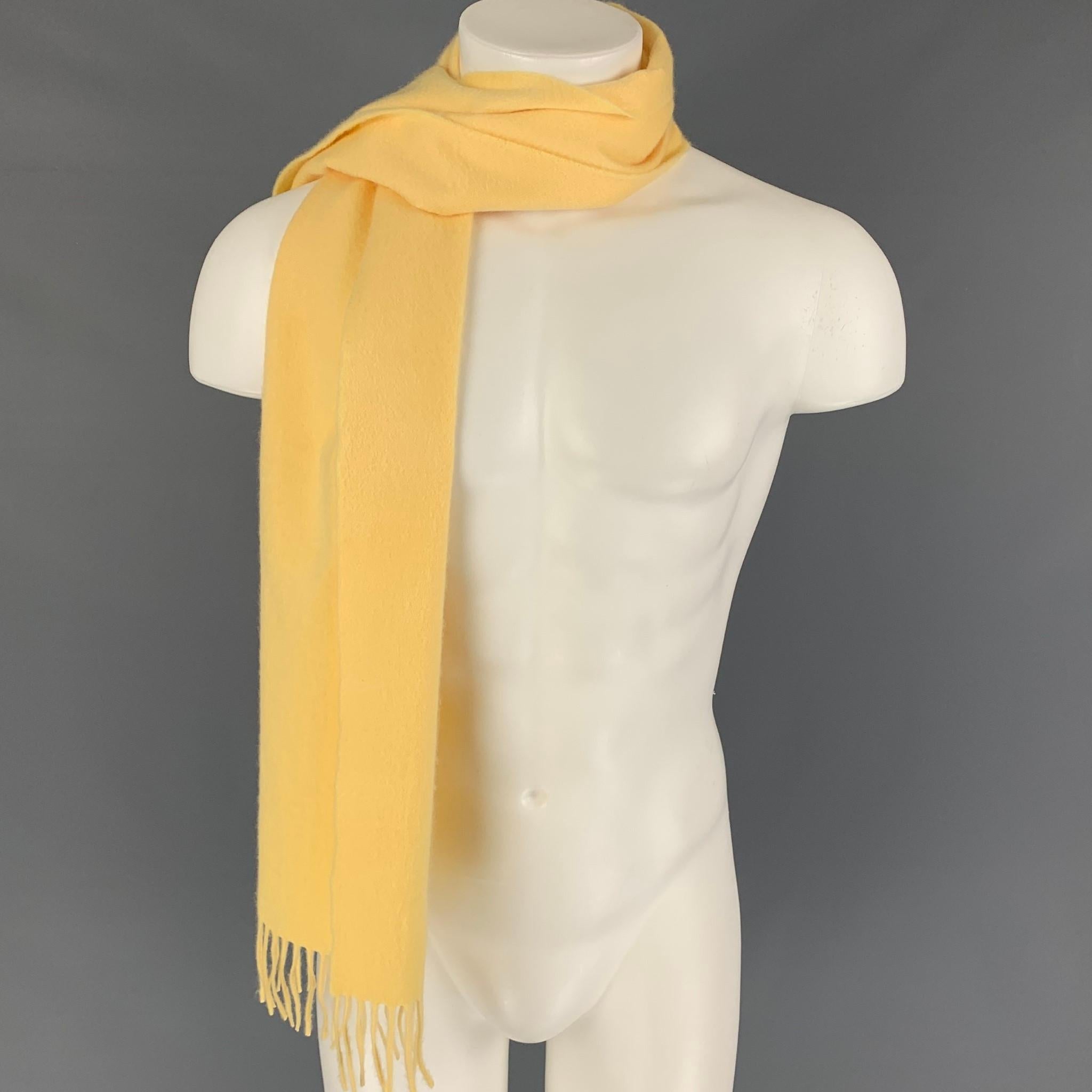SULKA scarf comes in a yellow cashmere featuring a fringe trim. 

Very Good Pre-Owned Condition.

Measurements: 55 in. x 12.5 in.