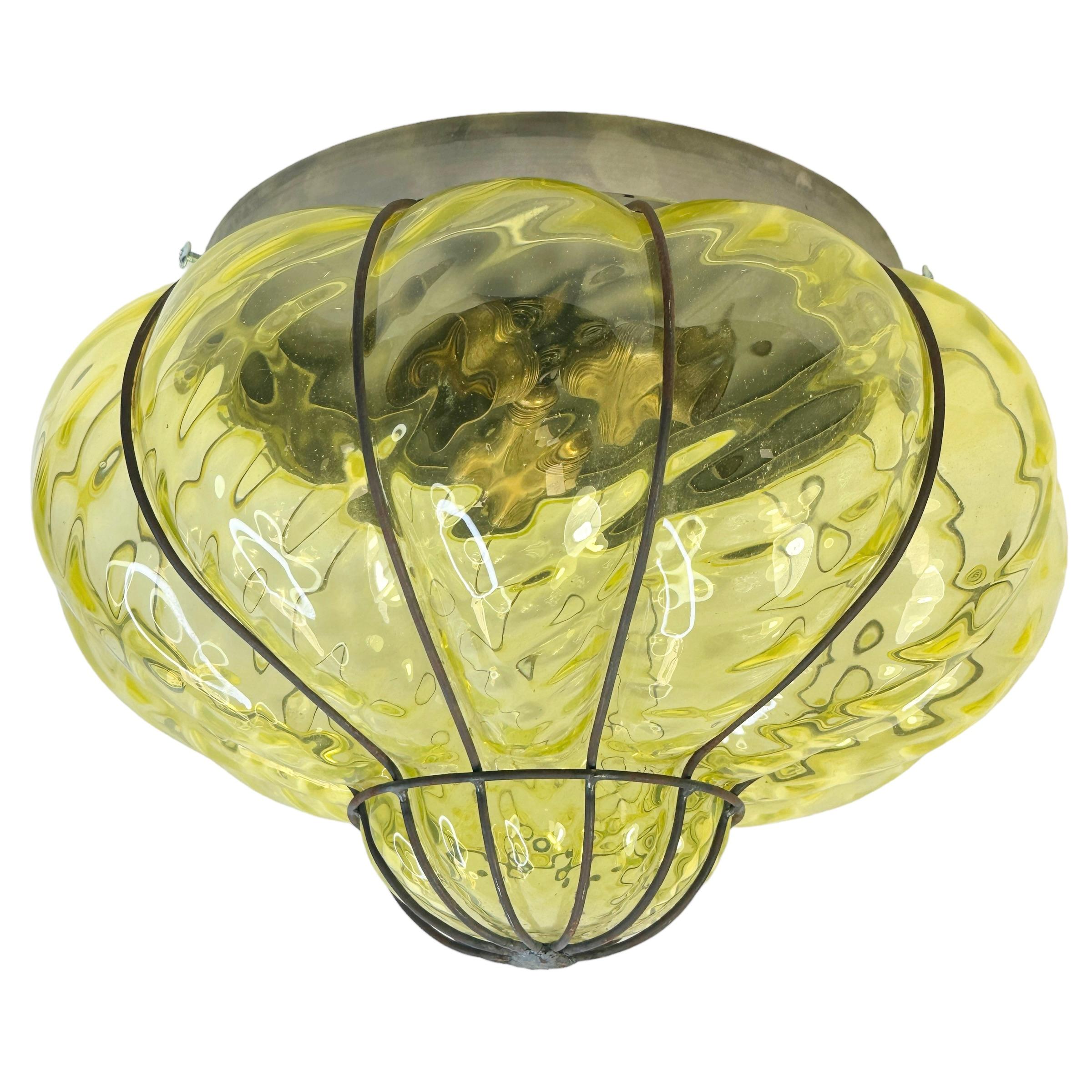 A hand blown Italian flush mount, fabulous Venetian caged light lime green glass in a iron frame. It can also be used as wall light as the globe is held tight to the fixture with screws. It is in fabulous vintage condition and has a new socket.