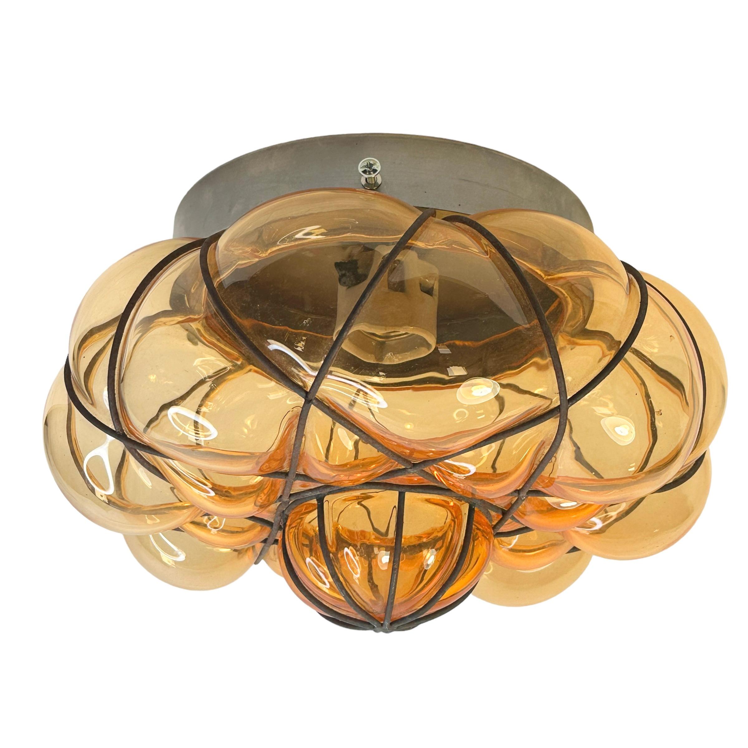 A hand blown Italian flush mount, fabulous Venetian caged light orange glass in a iron frame. it can also be used as wall light as the globe is held tight to the fixture with screws. It is in fabulous vintage condition and has a new socket. Please