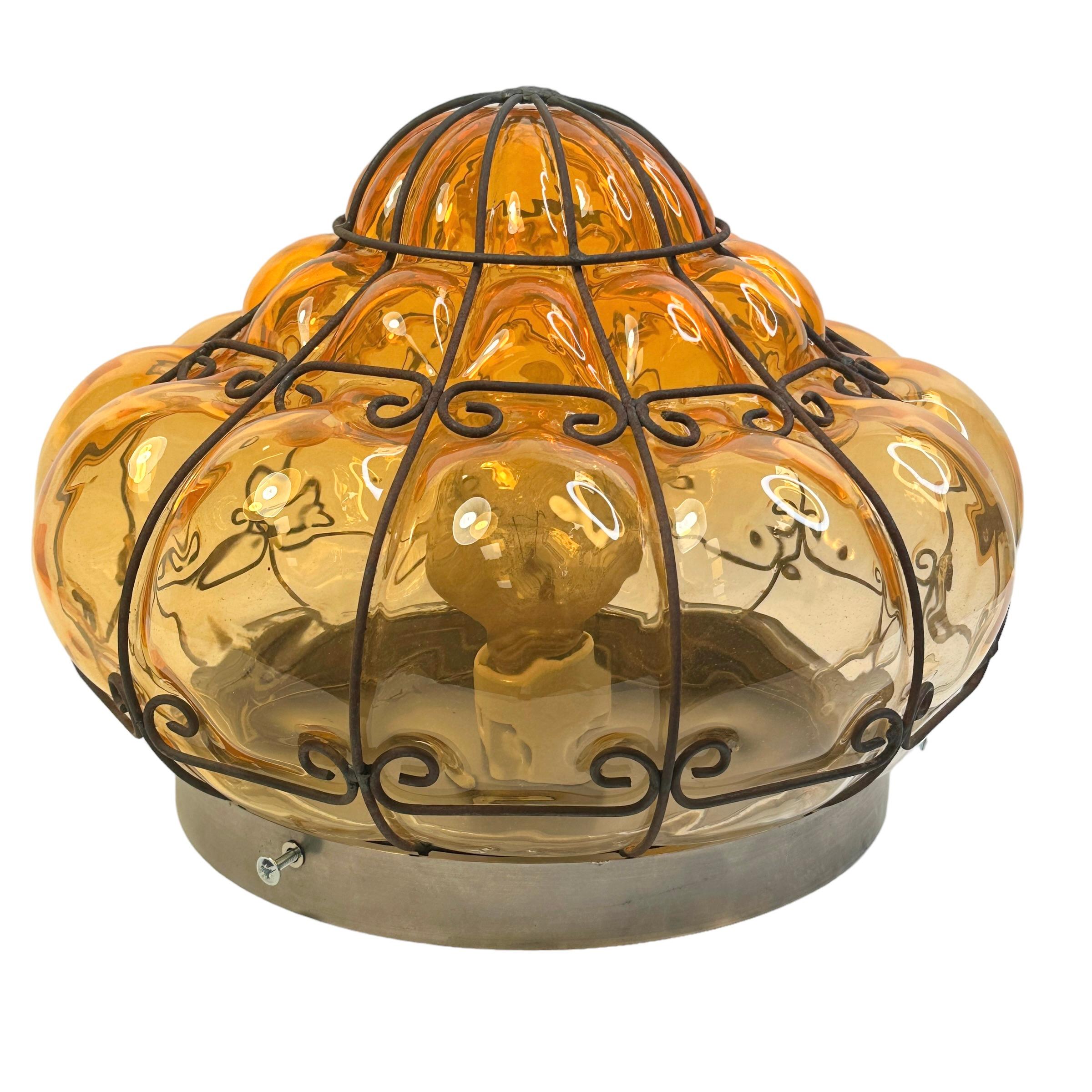 Un fabuleux verre vénitien orange soufflé à la main dans une monture en fer. Il peut également être utilisé comme applique murale car le globe est maintenu fermement au luminaire à l'aide de vis. Il est dans un état vintage fabuleux et dispose d'une