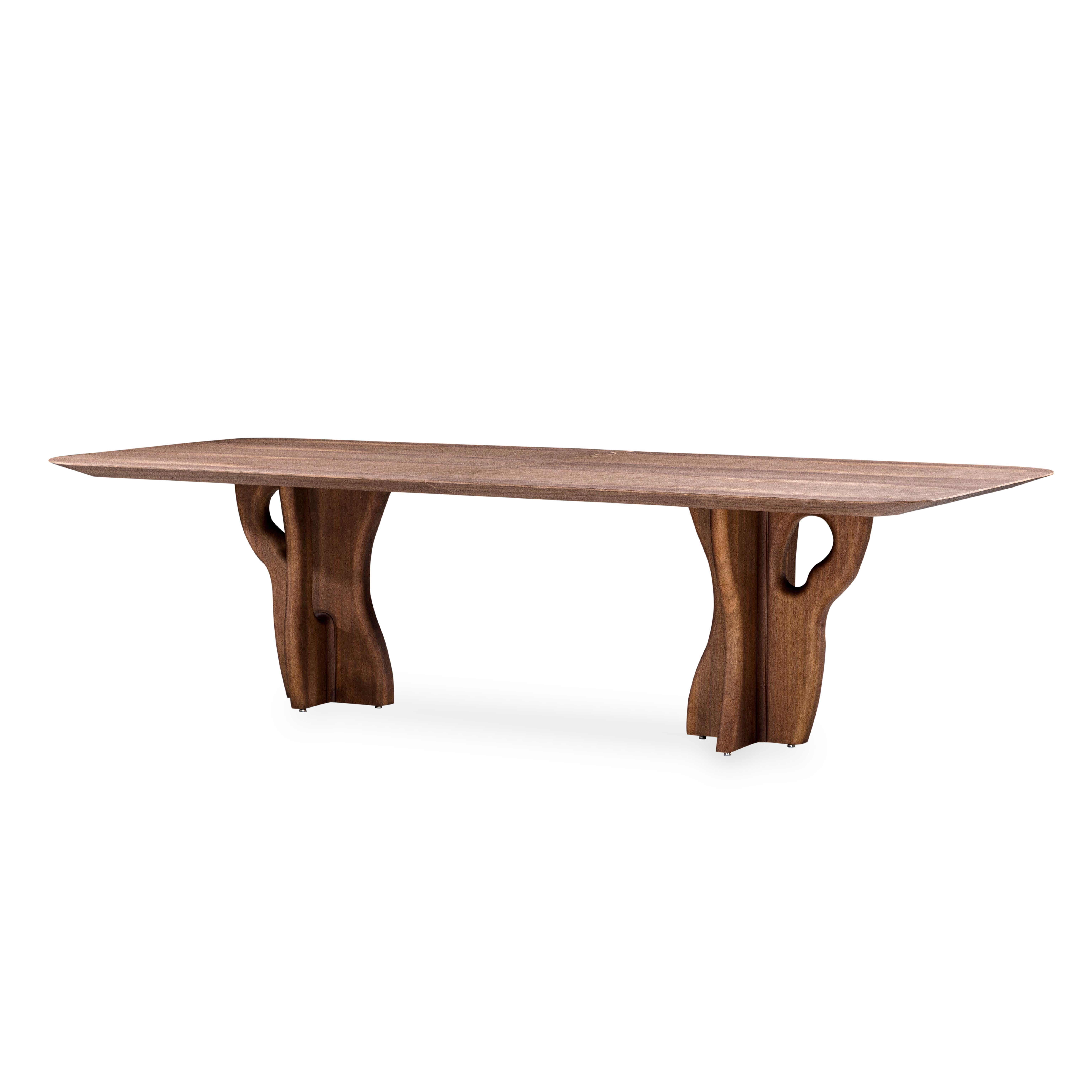 L'équipe de design d'Uultis a fabriqué la table de salle à manger Suma avec un plateau en finition plaquée noyer et des pieds en bois massif organique, parfaits pour votre espace de salle à manger rêvé. Il s'agit d'une pièce conçue pour être