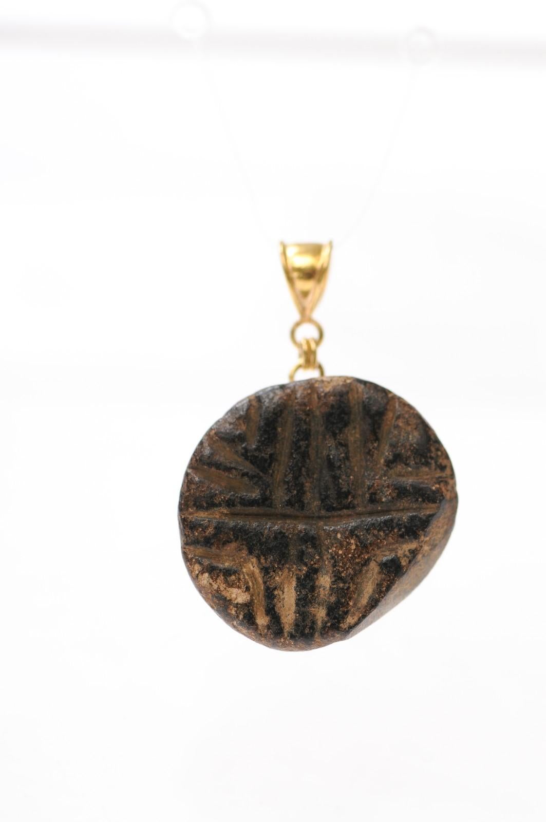 A Sumarian Steotite Stamp Pendant set with 18 karat gold bail. This rare and interesting Sumarian stamp is from circa 2000 BC, has dynamic lines etched on its surface, and has been set as a captivating pendant with a gold bail.  Steotite is a type