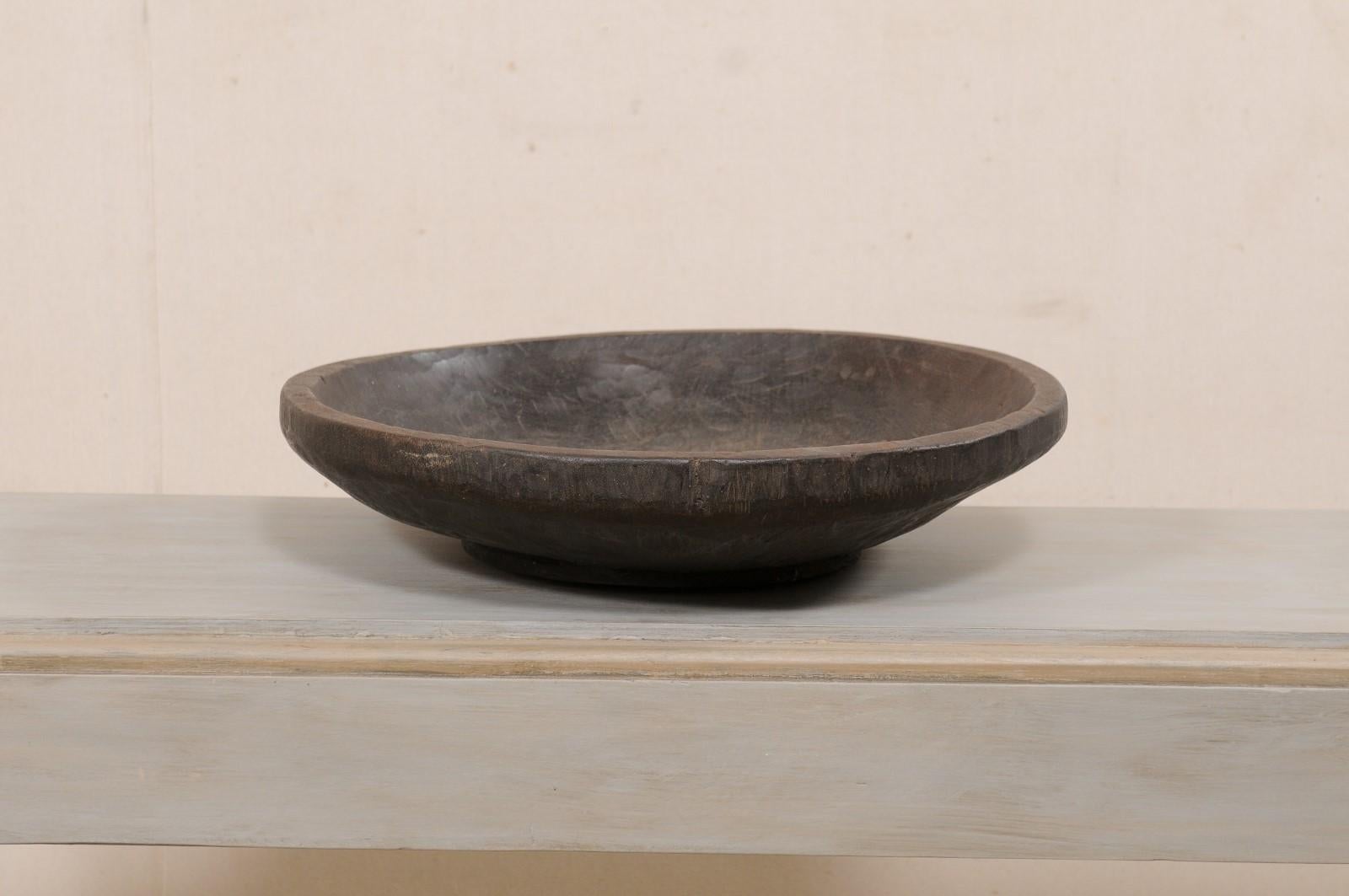 A Sumatran hand-carved wood bowl from the early 20th century. This antique wood bowl comes from the Lampung province of Sumatra, which is locate on the southern most tip of the island. This beautiful wood bowl has been hand carved from a single