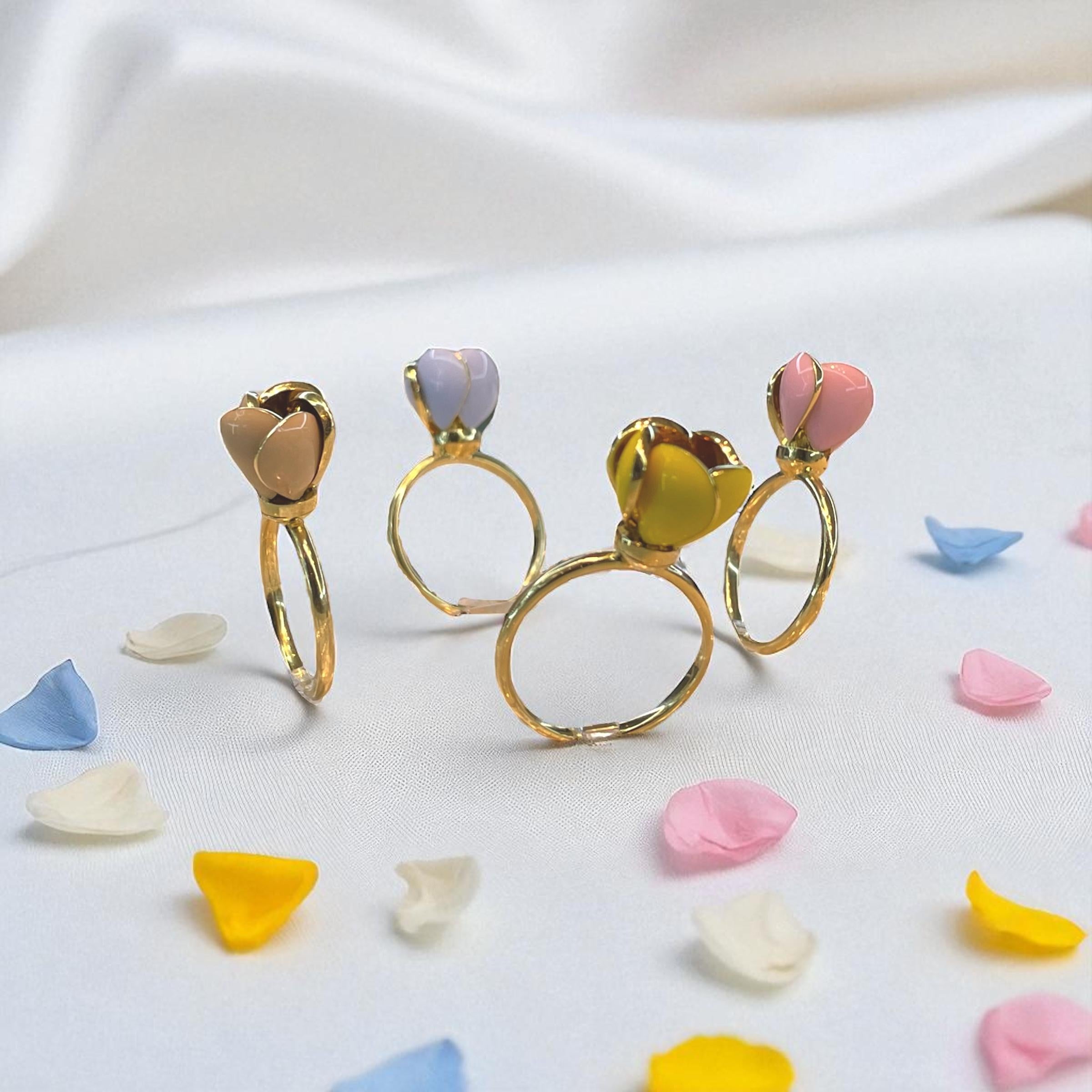 Expression ludique de la couleur et de la finesse de l'artisanat, chaque bague Enamel Blossom présente une fleur en émail sculptée à la main qui abrite en son centre une pierre précieuse naturelle de 0,20 carat. Conçues en métal doré poli, ces