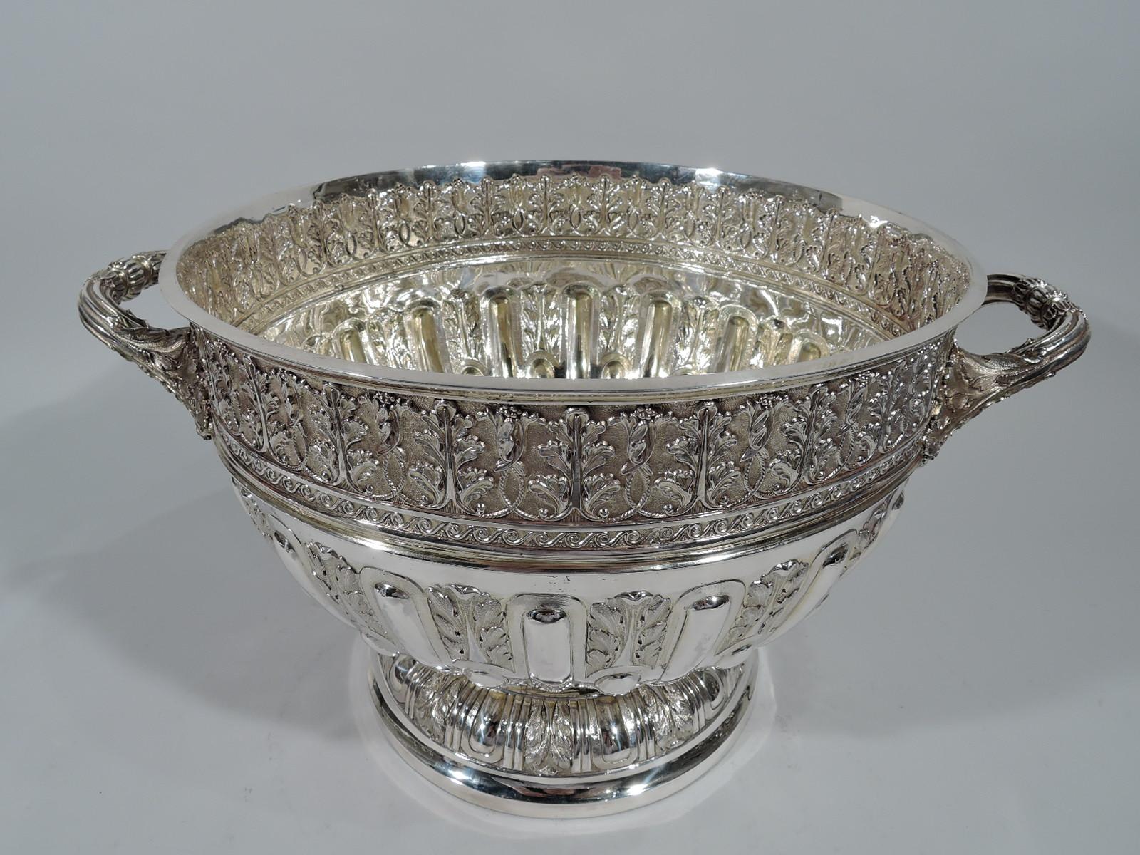 Victorian sterling silver centerpiece bowl. Made by John Newton Mappin in London in 1890. Curved sides, domed foot, and leaf-mounted bracket handles. Big and bold Classical ornament. Sides have alternating gadroons and foliate flutes bisected with