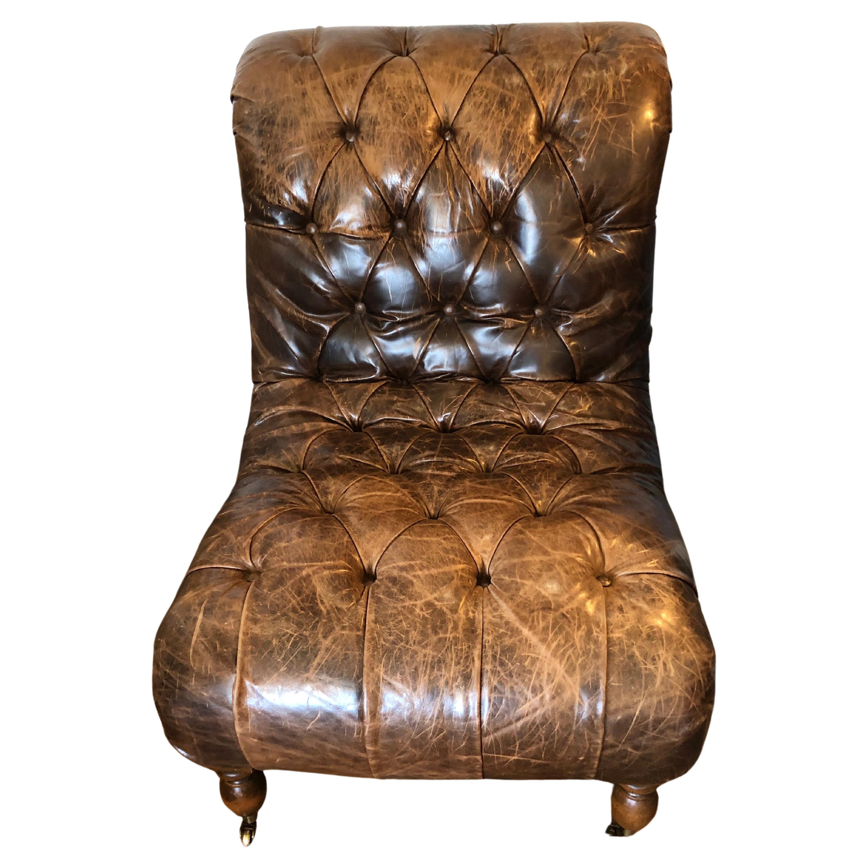 Handsome pair of distressed tobacco brown tufted leather club chairs having no arms in a slipper chair silouette.  Super comfy and stylish.