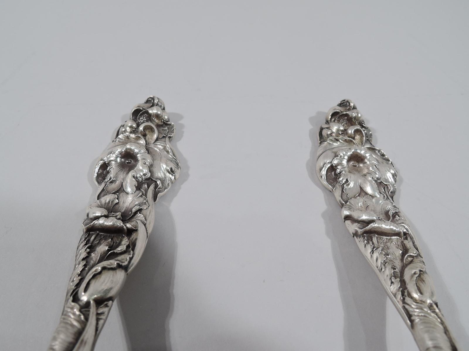 Turn-of-the-century Six Fleurs sterling silver salad serving, pair. Made by Reed & Barton in Taunton, Mass. This pair comprises spoon and fork. Each: cast handle comprising dense and overlapping flowers and leaves. On back strewn flowers and leaves.
