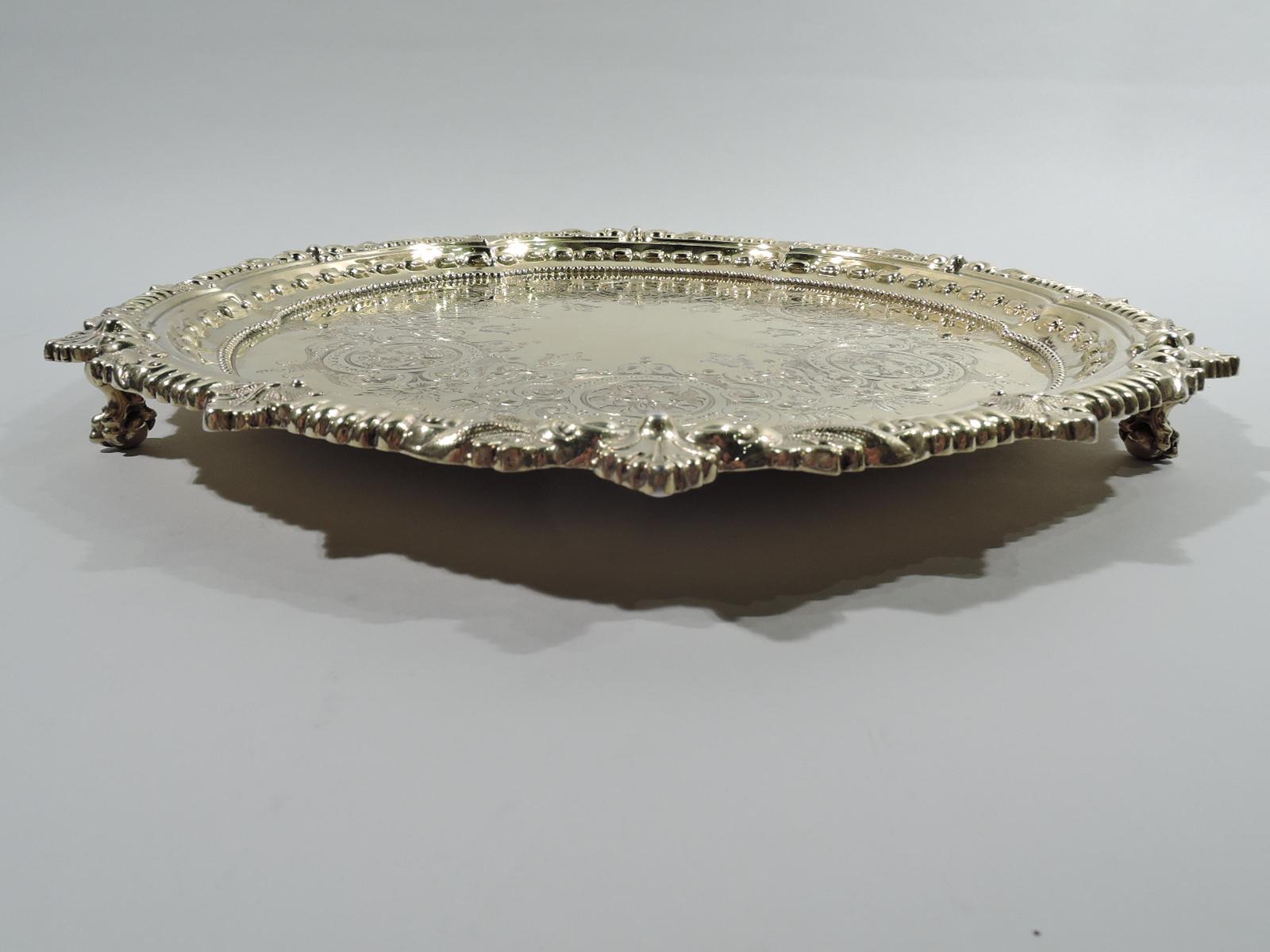 Sumptuous Regency Revival gilt sterling silver salver. Made by Howard & Co. in New York in 1900. Round and lobed well with vacant center and leaf-and-flower rondel border. Applied beading and embossed leaf-and-berry. Rim gadrooned and interspersed