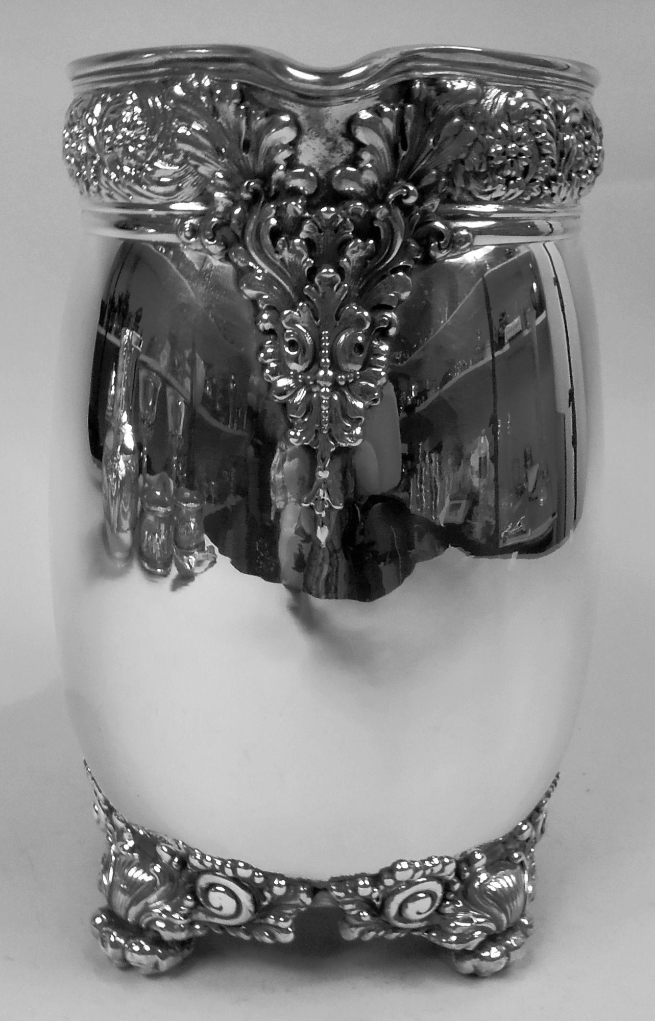 Suntuosa jarra de agua victoriana clásica de plata de ley. Fabricado por Tiffany & Co. en Nueva York. Cuenco curvo con banda de rinceaux repoussé incrustada con cabezas de flores. El caño del labio tiene una montura aplicada de hoja y concha con una