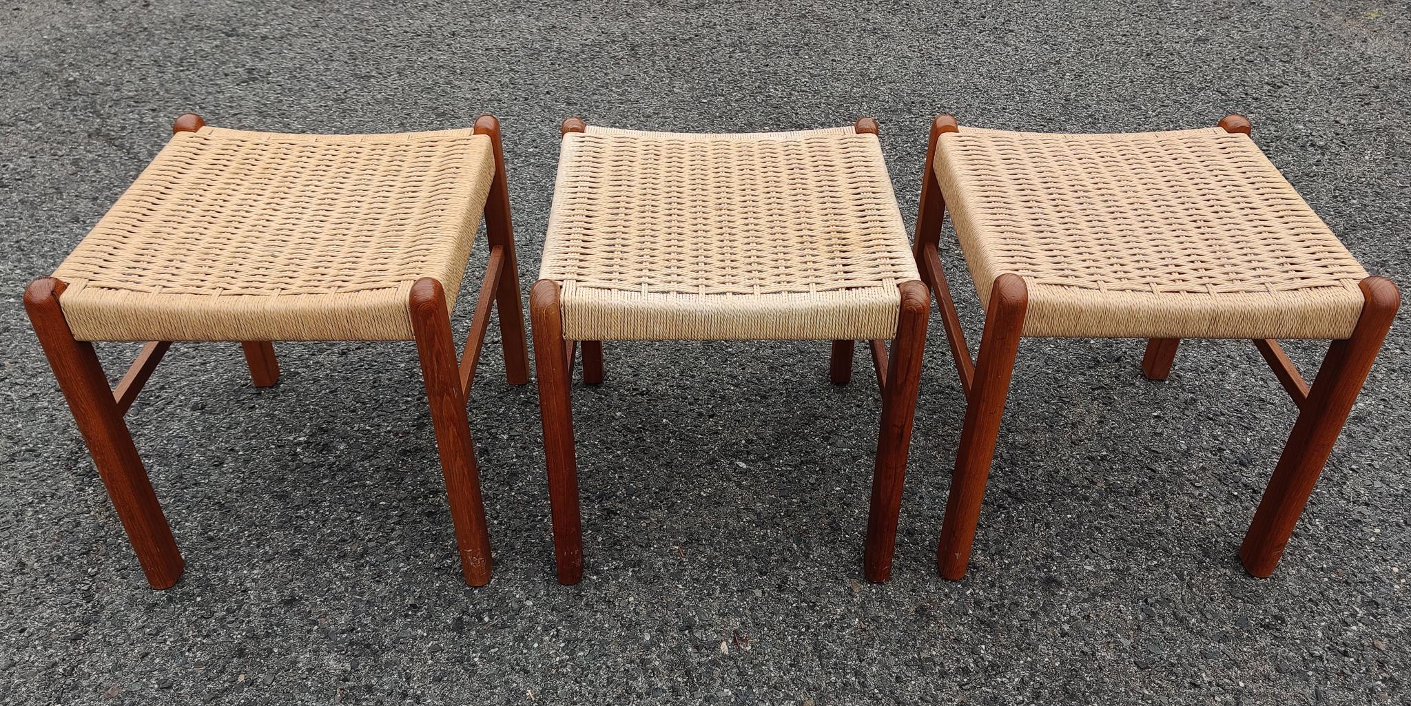 A great trio of well made solid teak construction stools or benches, with paper-cord seats. These small personal benches fit comfortably in a room of any style and size. Oiled teak, curved seats, warm patina, these are just some of the features that