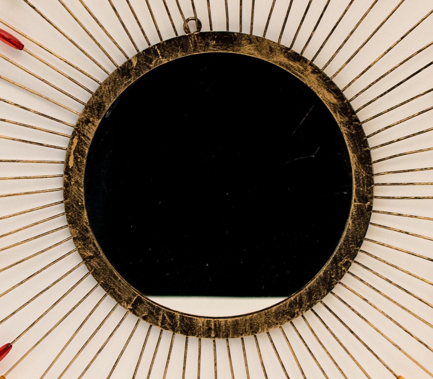 Vintage design
- Sun mirror from the 1960s
- Designed in the style of Line Vautrin
- Colorful plastic beads and metal leaves.