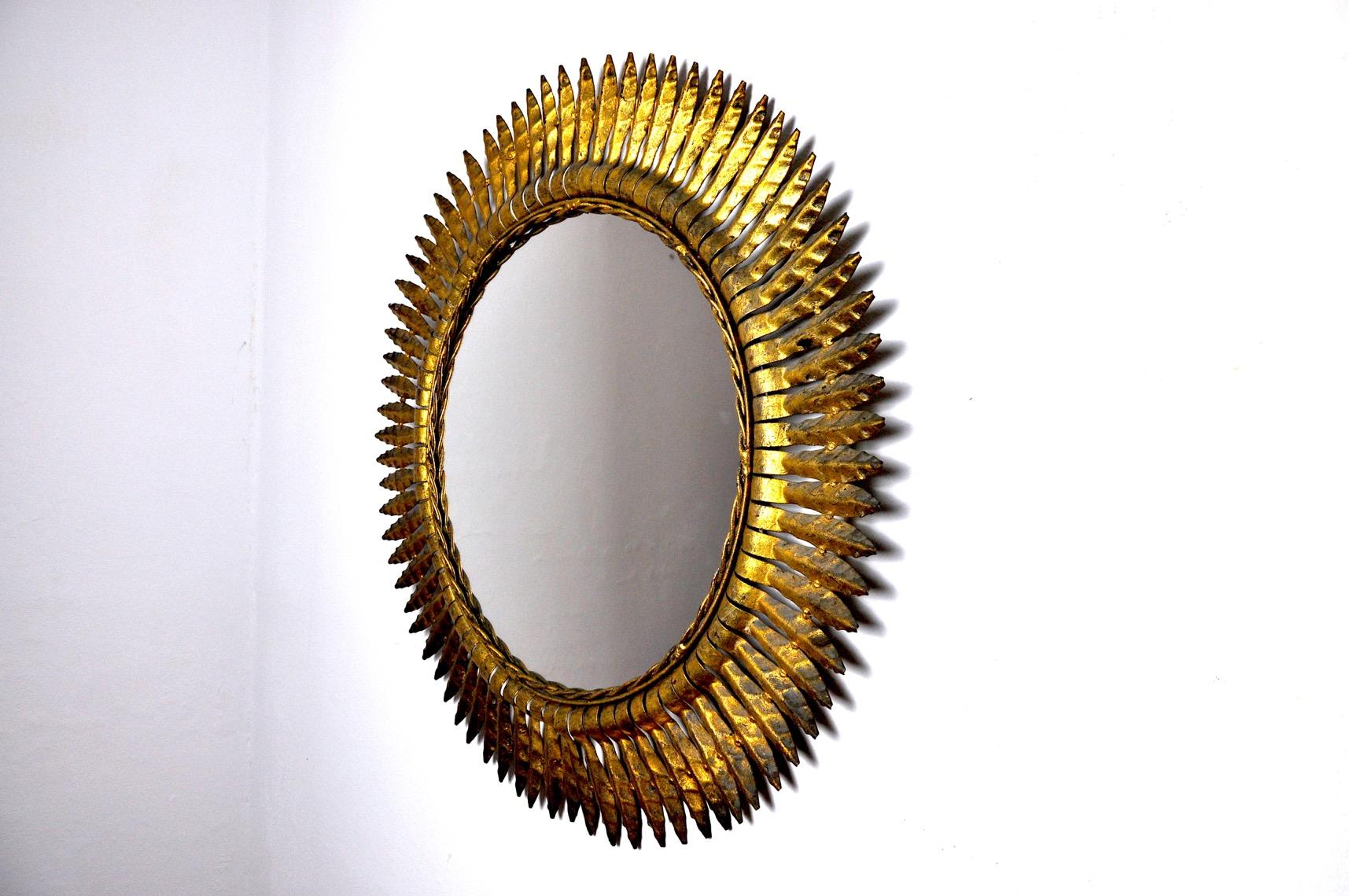 Large golden metal sun mirror from the 60s produced in Italy. Superb metal work, gold leaf finish. In perfect state of conservation. Unique objects that will decorate wonderfully and bring a real design touch to your interior. Ref: 732.

