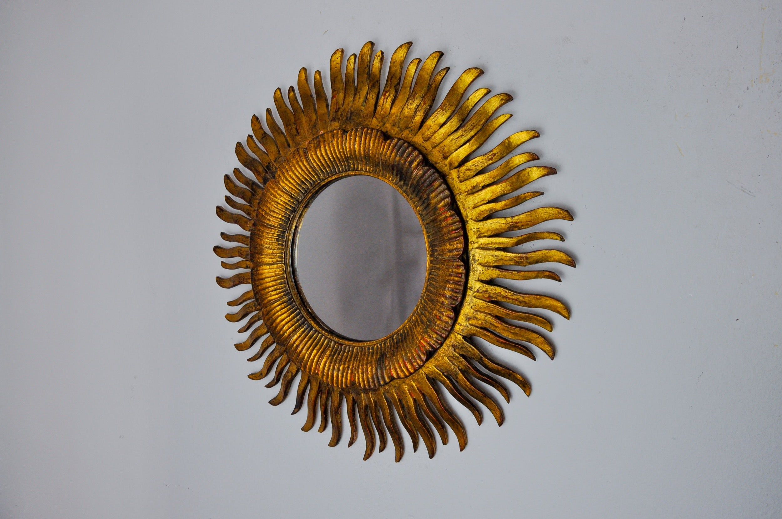 Very beautiful wooden sun mirror gilded with gold leaf dating from 1960. Superb wood work. Good state of conservation with very beautiful patina. Superb for illuminating your interior. Ref: 1030. Diameter: 47 cm.