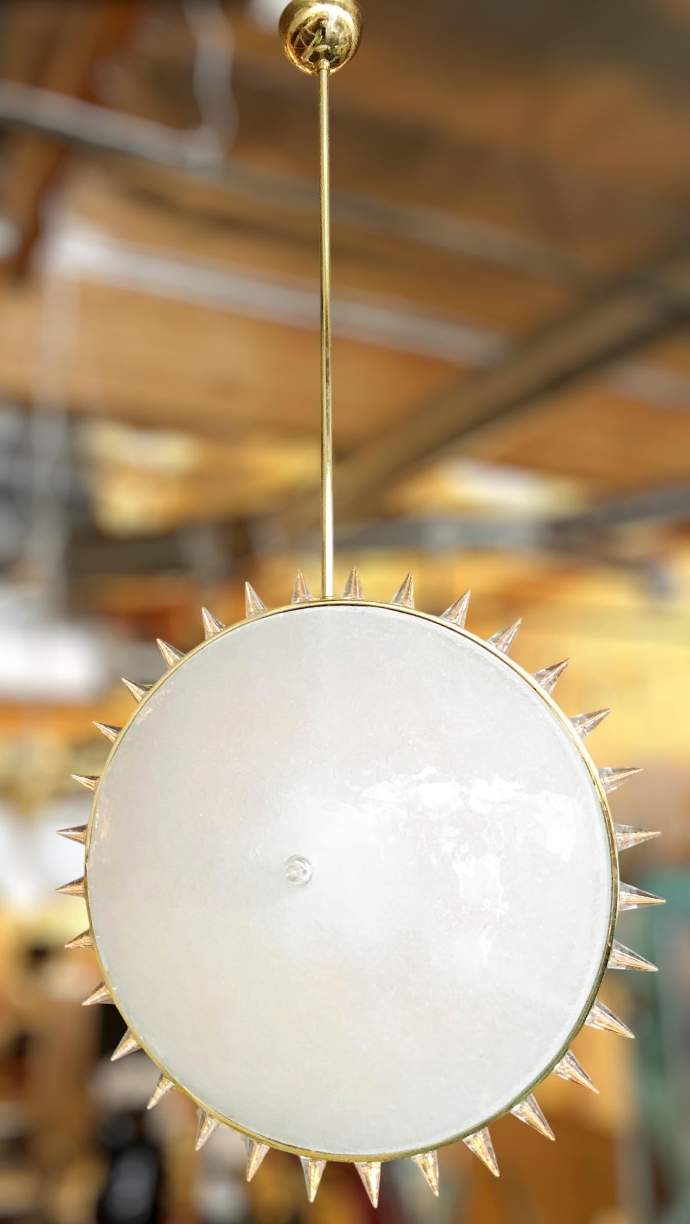 Grande pendente italiano in vetro di Murano, composto da 2 paralumi rotondi in vetro smerigliato, con punte in vetro trasparente montate su una struttura in ottone lucido 
Disegnato da Gianluca Fontana per Fabio Ltd / Made in Italy
6 luci / tipo E26