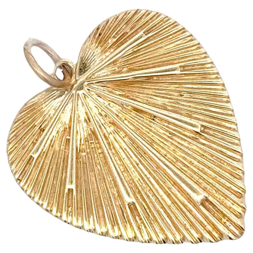 Fabriqué en Italie, ce pendentif en forme de cœur présente un motif de rayon de soleil et pèse 5,3 grammes, en or jaune 14 carats. 

Collier non inclus.
DM pour différentes options de colliers.
D'autres pendentifs en forme de cœur sont