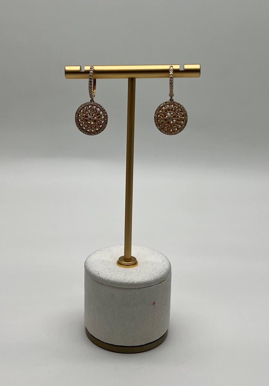 These earrings feature intricate circular designs with a lattice pattern. The earrings are adorned with sparkling diamonds, adding a touch of elegance. The drop design is complemented by a sleek, polished finish. 14K Yellow Gold. 0.60 CTW Diamonds.