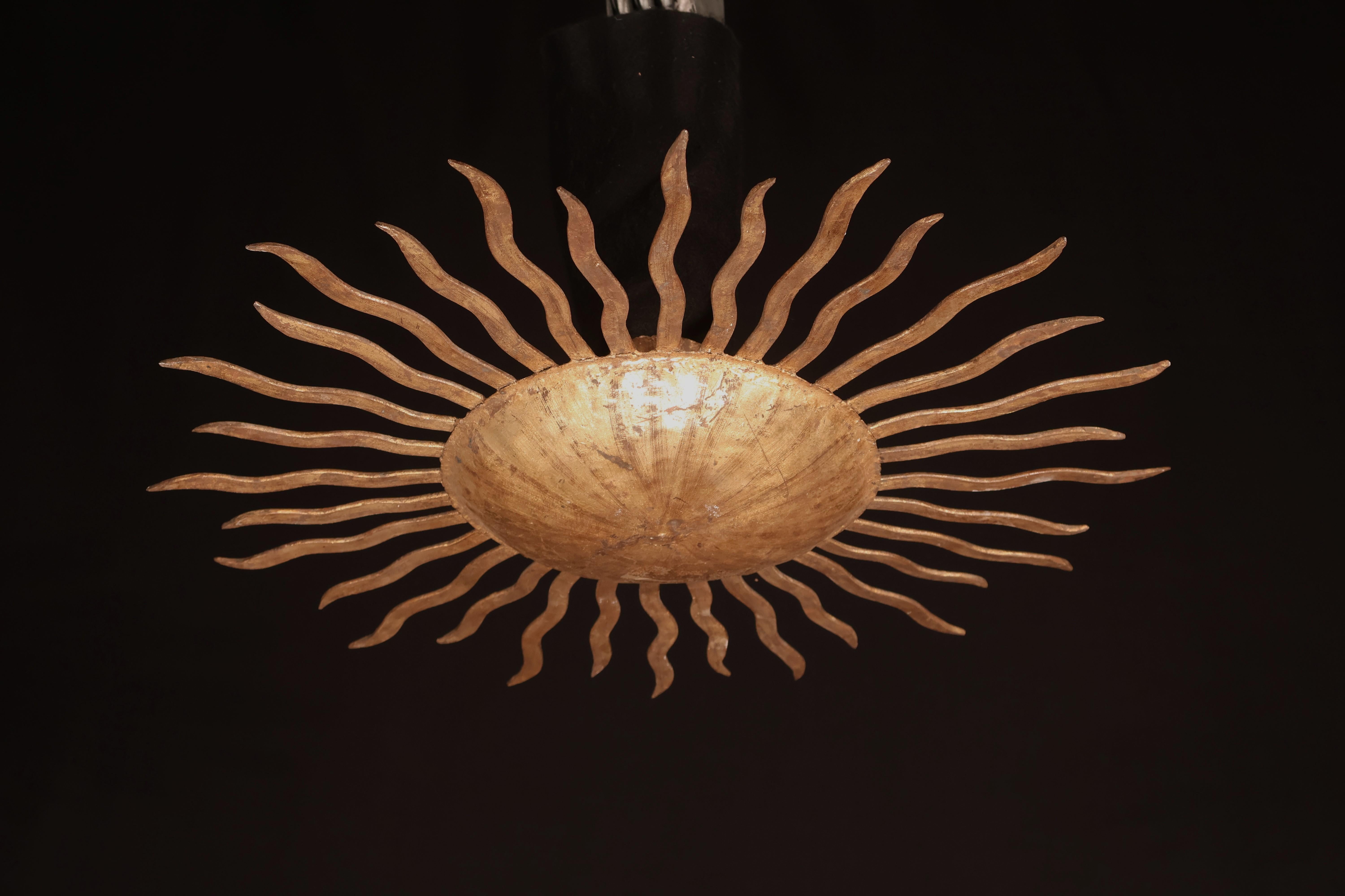 Un raffinato ed elegante ciondolo a forma di sole in ferro dorato. 2 luci.
Italia, circa 1960.
Dimensioni: Altezza 6