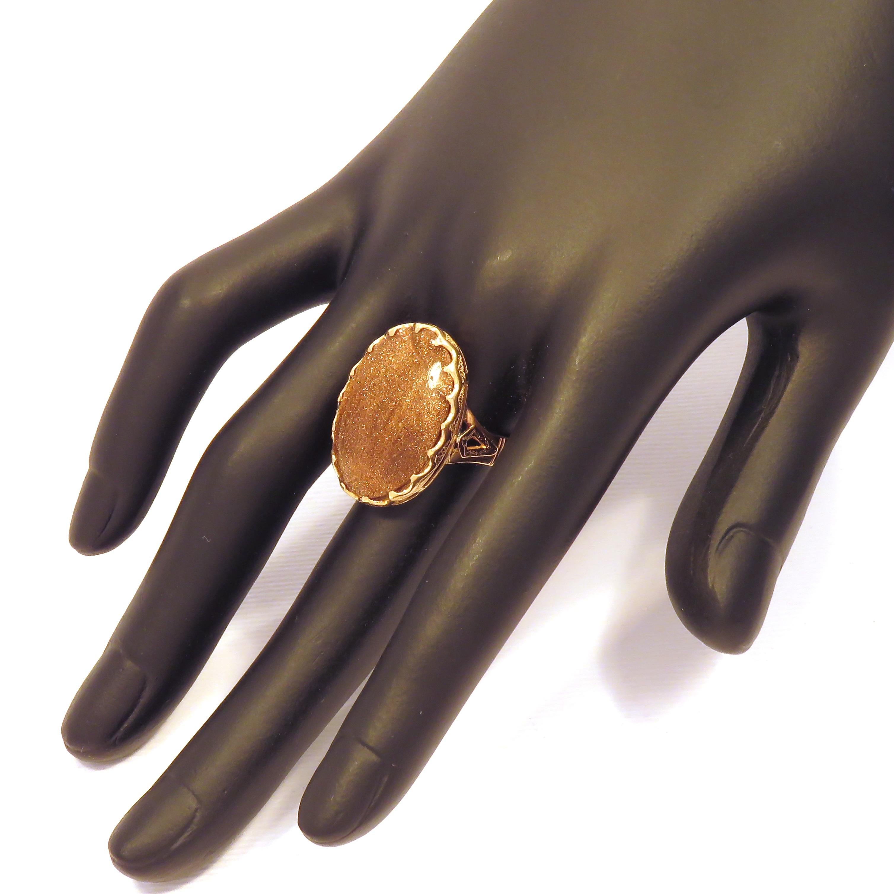 This vintage ring features a large natural oval cabochon sun stone perched on the top of an 18 karat rose gold engraved shank dating 1970'. The size of the stone is 24x18 mm / 0.944x0.708 inches. US finger size is 7.75, French size 56, Italian size