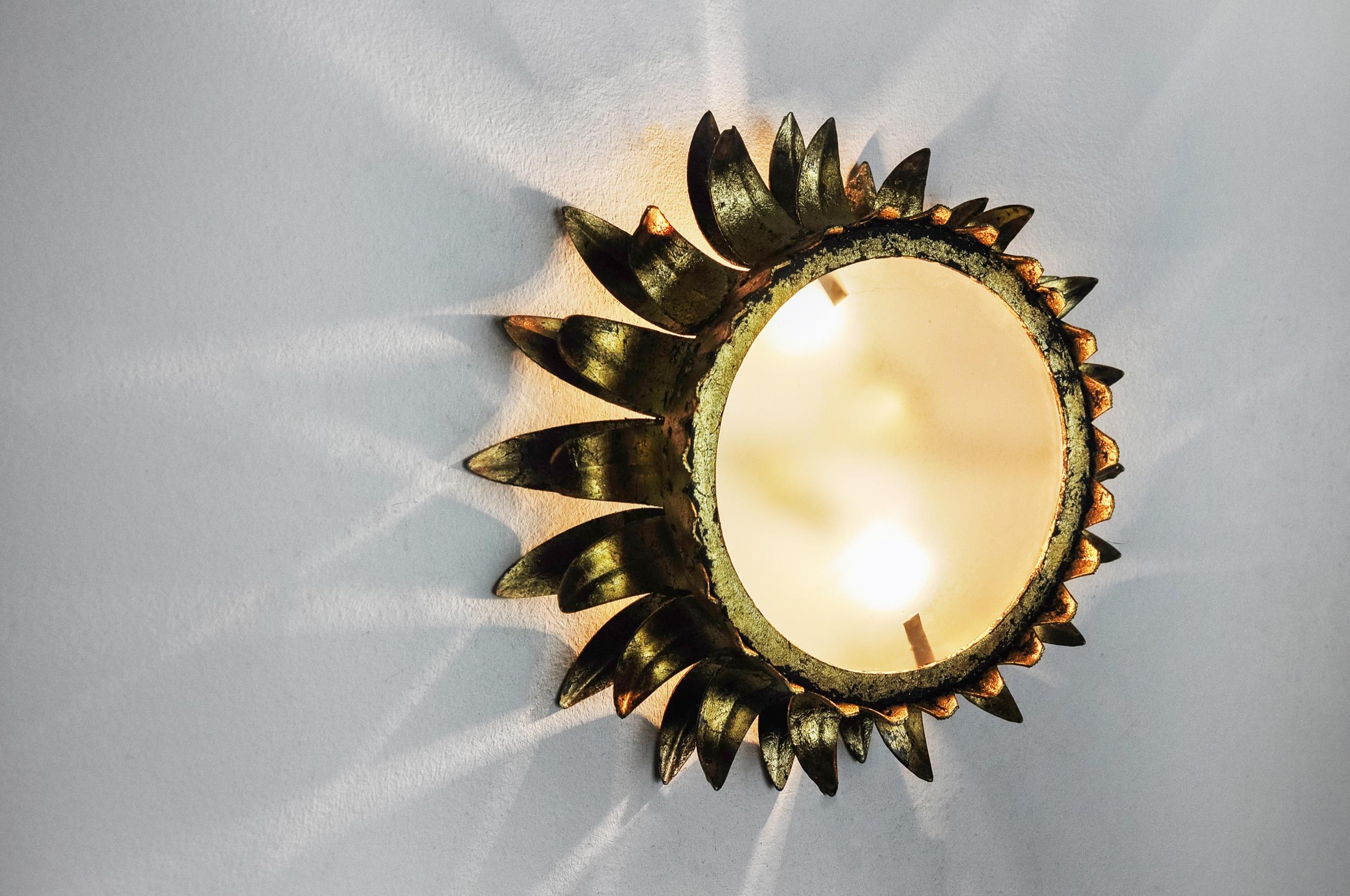 Very beautiful and large sun wall light, designed and produced by Ferro Arte in Spain in the 1960s. Structure in metal gilded with gold leaf and opaline glass. Unique objects that will illuminate marvelously and bring a real design touch to your
