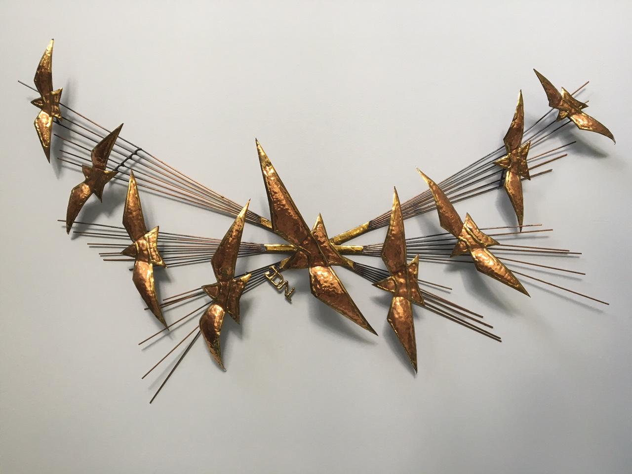 Offered is a 1970s-early 1980s vintage metal wall sculpture features birds and a sunburst motif. Marked 