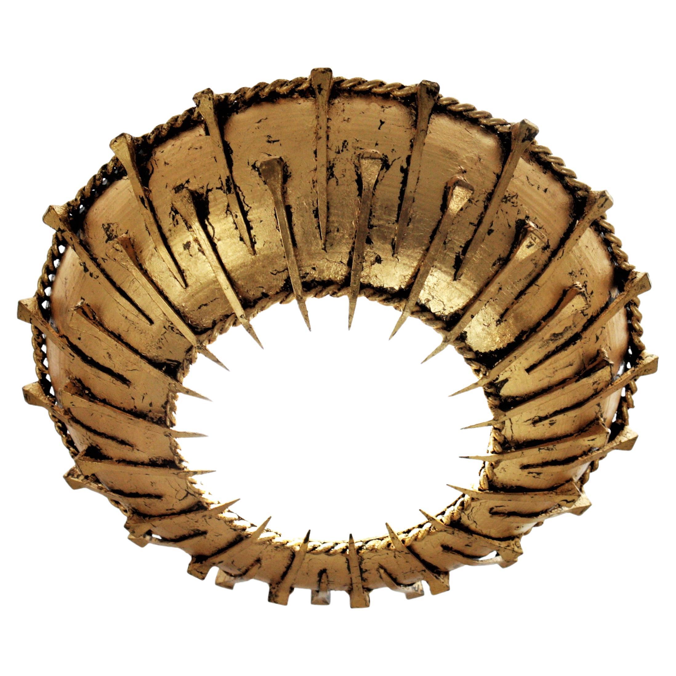 A Brutalist gilt wrought iron sunburst flushmount or light fixture from the Brutalist period, France, 1950s.
It has a frosted glass diffuser in the centre and a double layer of iron nails decoration. It was finished with gold leaf gilding and it