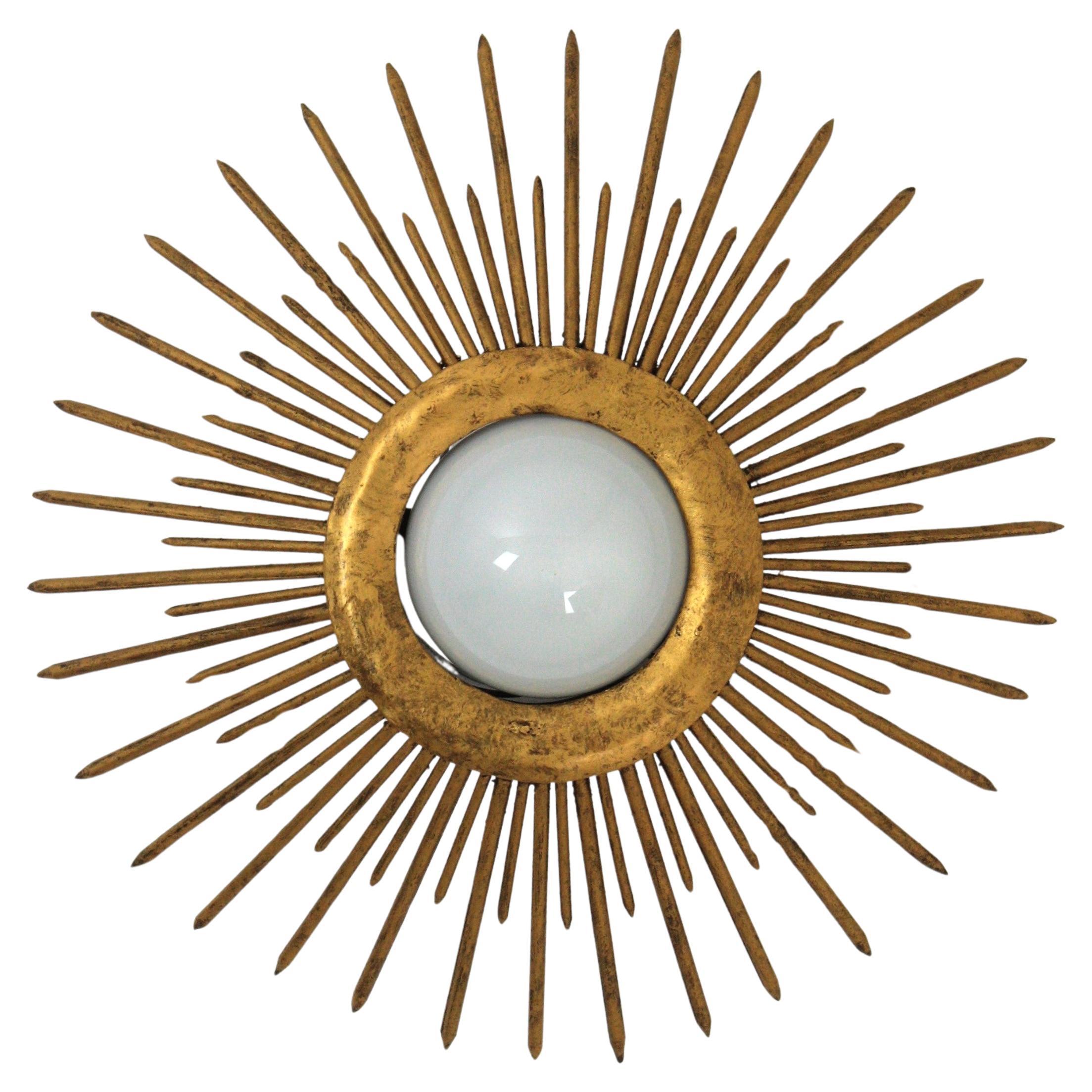Eye-catching Gilt Iron Sunburst Nail Design Ceiling Light Fixture
France, 1940s.
Wrought sunburst flush mount with spikes design in gilt iron.
This stunning sunburst ceiling light shows a strong design with pointed spikes in sunburst disposition. It
