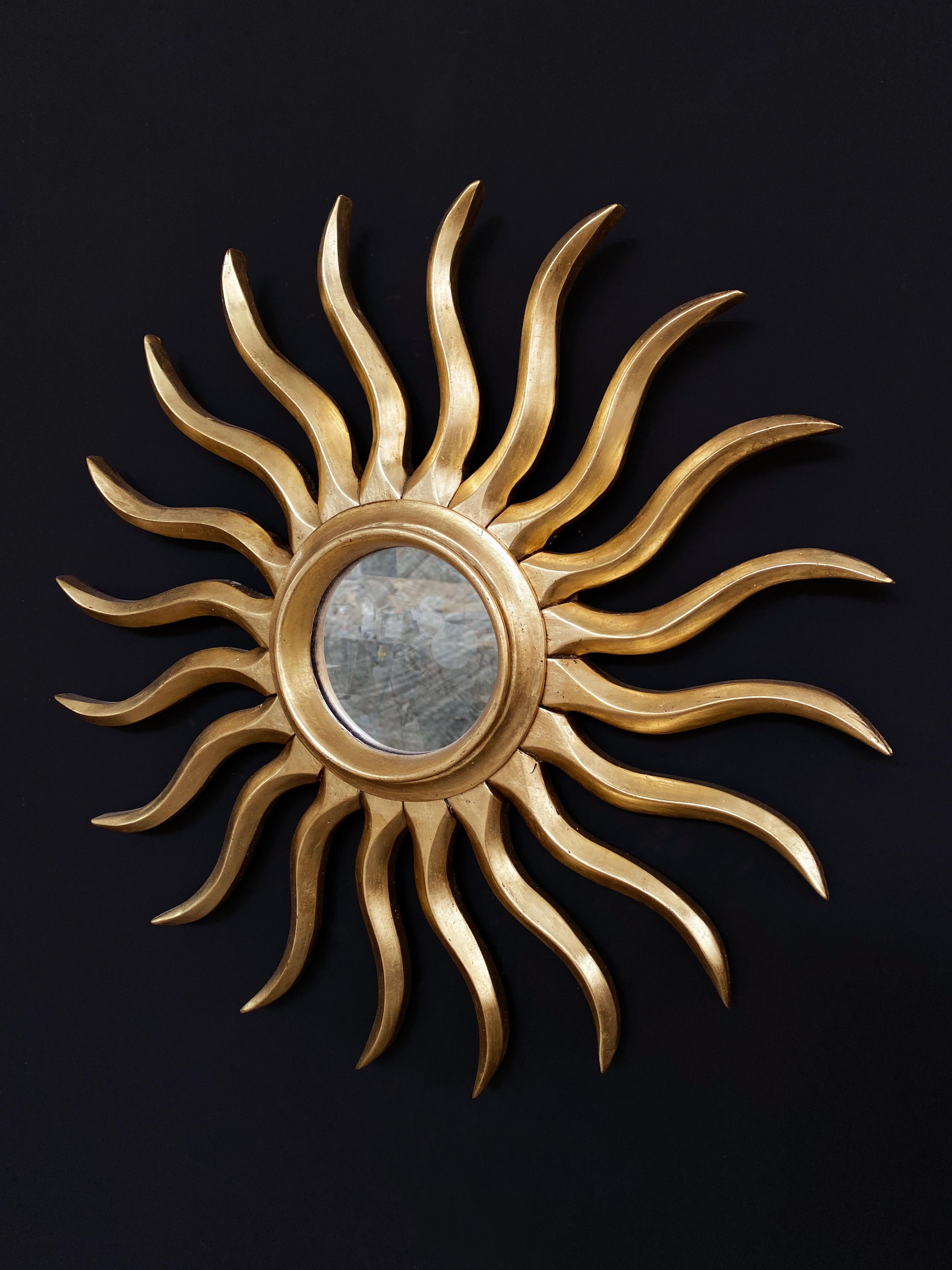 Hand-carved and gilded vintage mirror, crafted from wood and finished with traditional gold leaf techniques. It features twenty wooden rays with refined Art Nouveau influence. A distinctive piece that adds sophistication to any space.

Dimensions: