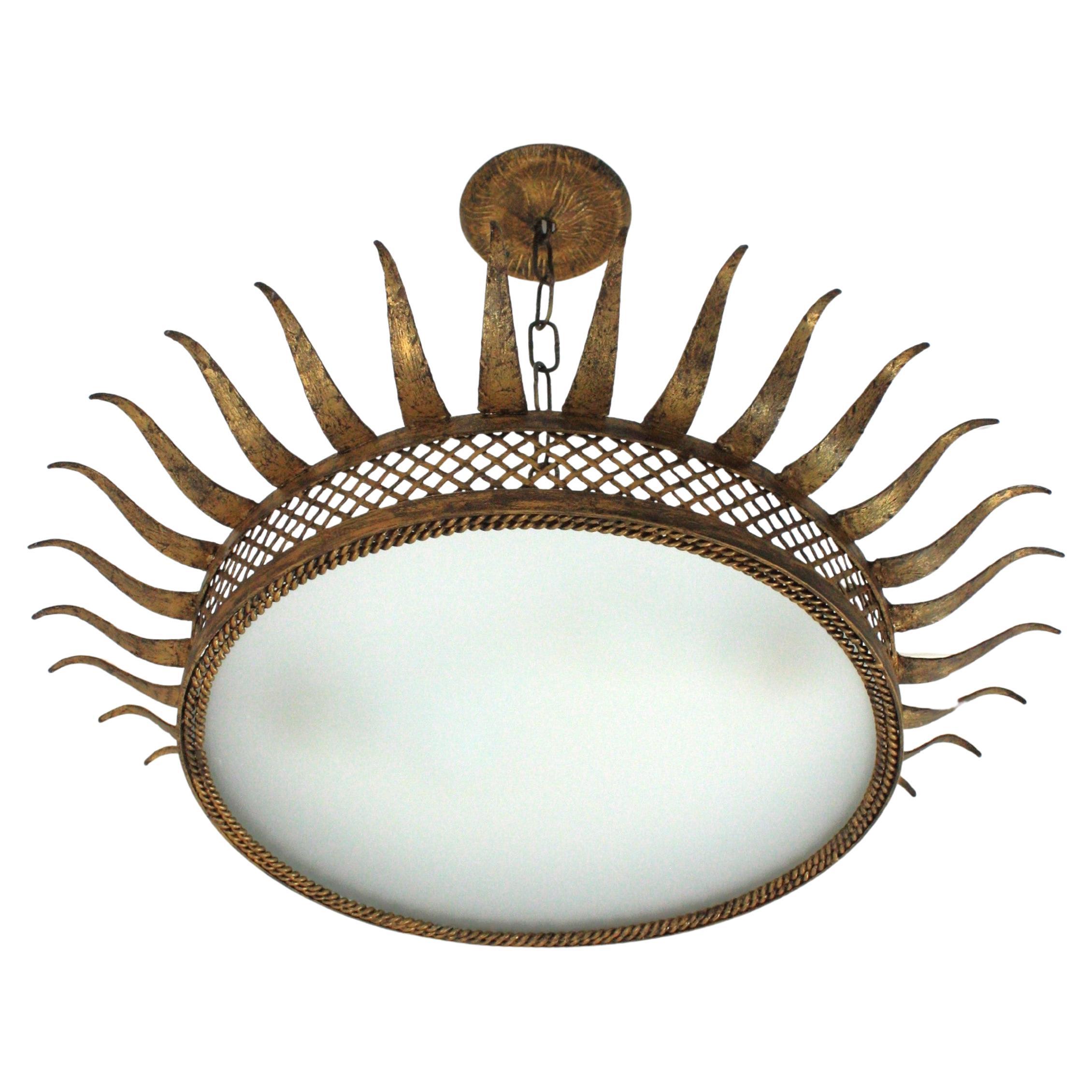 Große Sunburst Starburst Flush Mount Leuchte, vergoldetes Eisen, mattiertes Glas
Frankreich, 1950er Jahre
Mid-Century Modern vergoldetes Eisen mit Sonnenschliff und Gittermotiven, die den zentralen Glasdiffusor umgeben
Dieses atemberaubende Stück