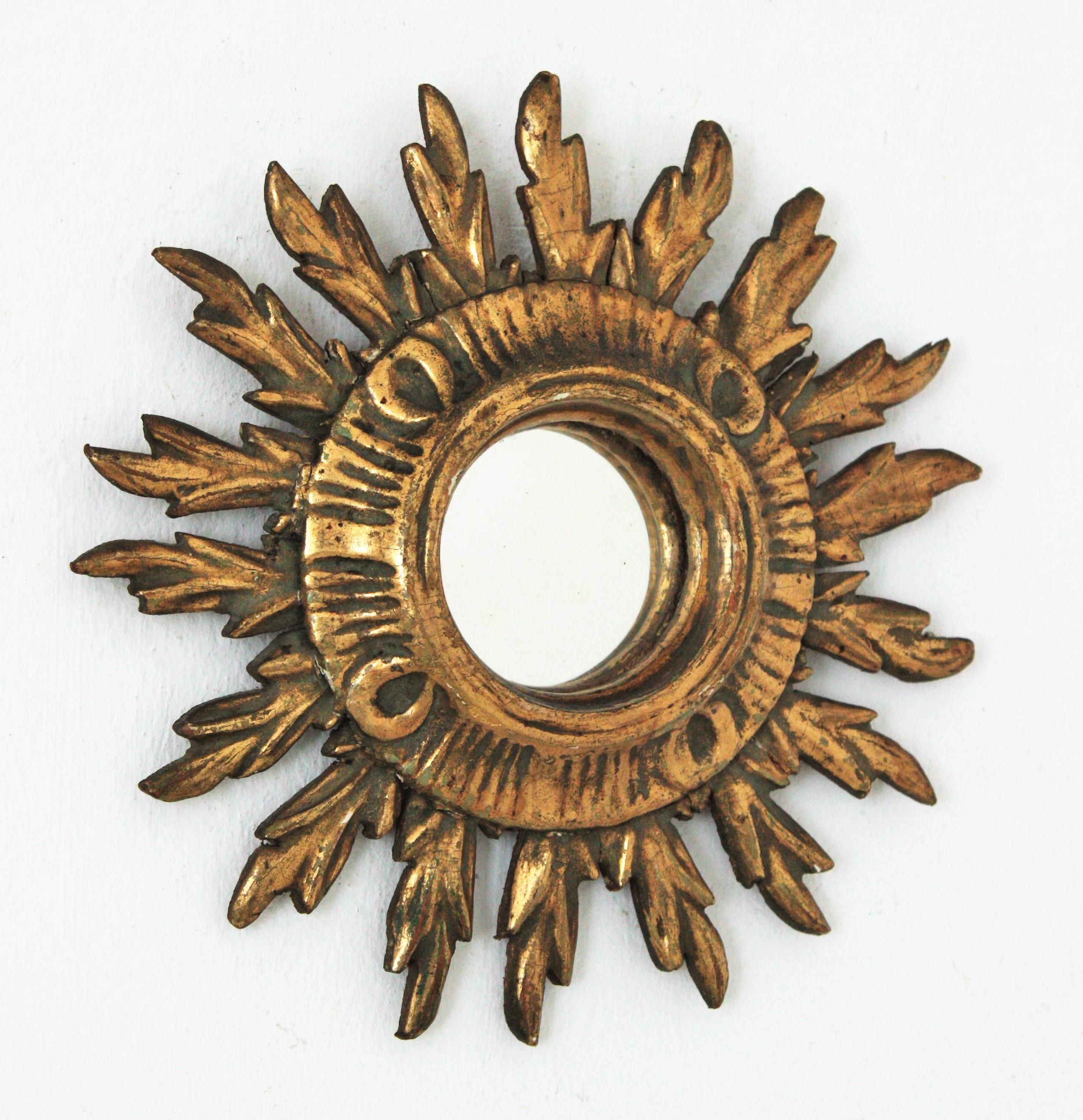 Carved giltwood convex sunburst mirror, Spain, 1930s
Early 20th century carved gold leaf giltwood mini sized sunburst mirror in Baroque style.
This eye-catching sunburst mirror features a sunburst frame with 18 rays. Unusual mini size. Carved wood