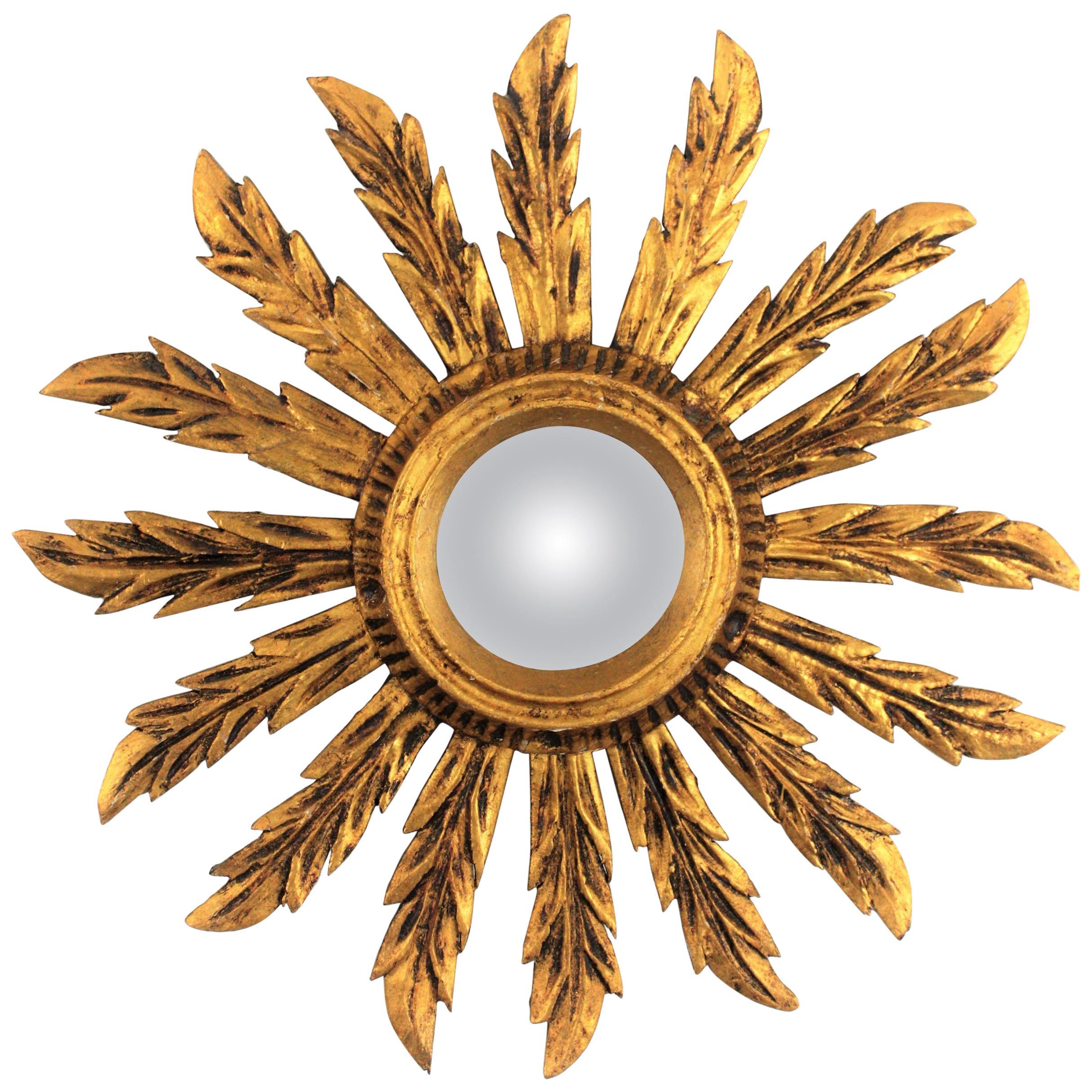 Spanish 1920s Baroque style carved giltwood sunburst convex mirror
Beautiful unusual small sized Baroque style giltwood sunburst mirror with convex glass.
Carved wood covered with gesso and gold leaf finish.
The frame has a lovely aged