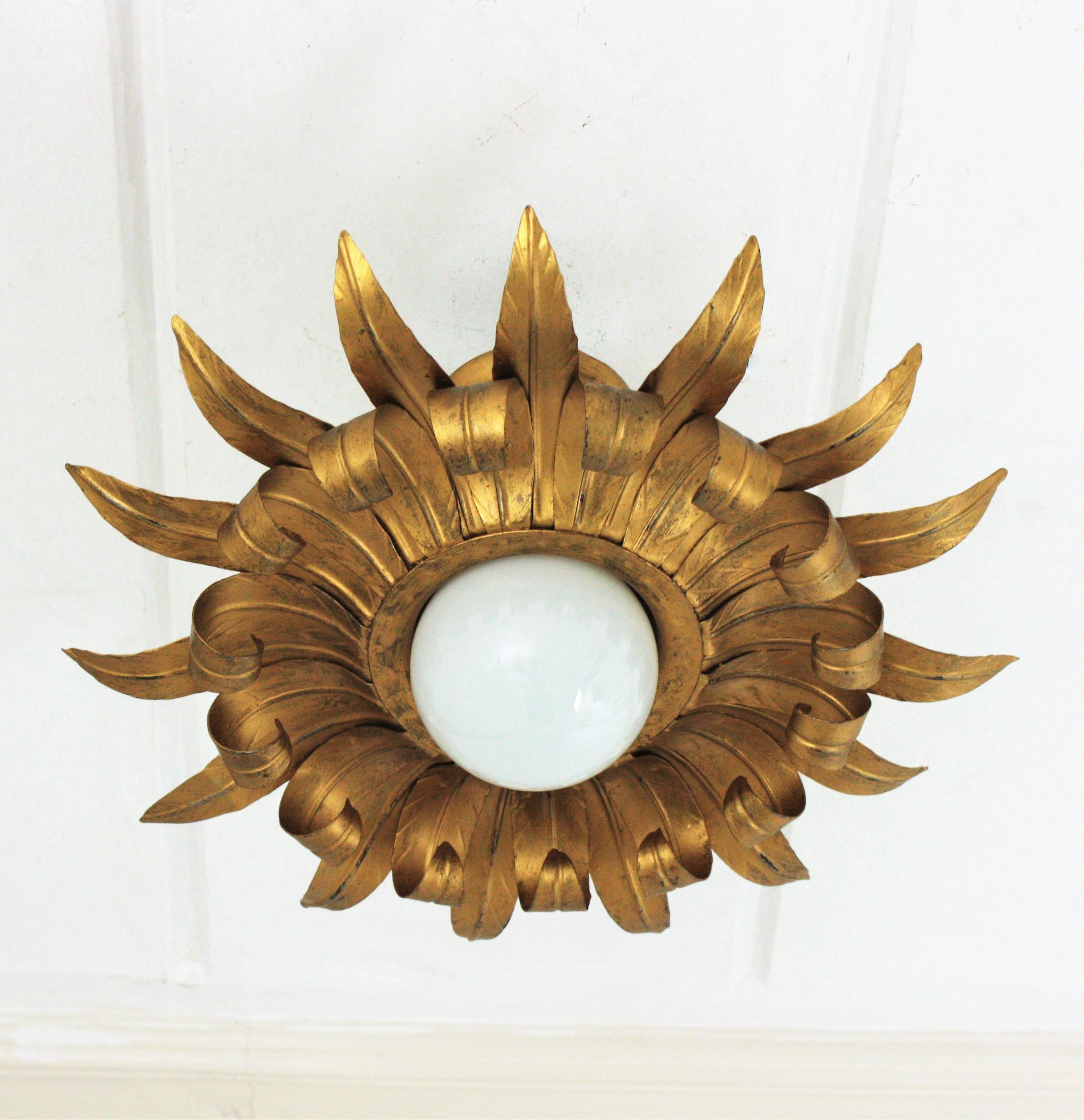 Brutalist gilt metal sunburst light fixture, France, 1950s.
Eye-catching iron sunburst flush mount with alternating rays in eye-lash shape.
It can be placed as ceiling light fixture or as a pendant hanging from a chain at the desired
