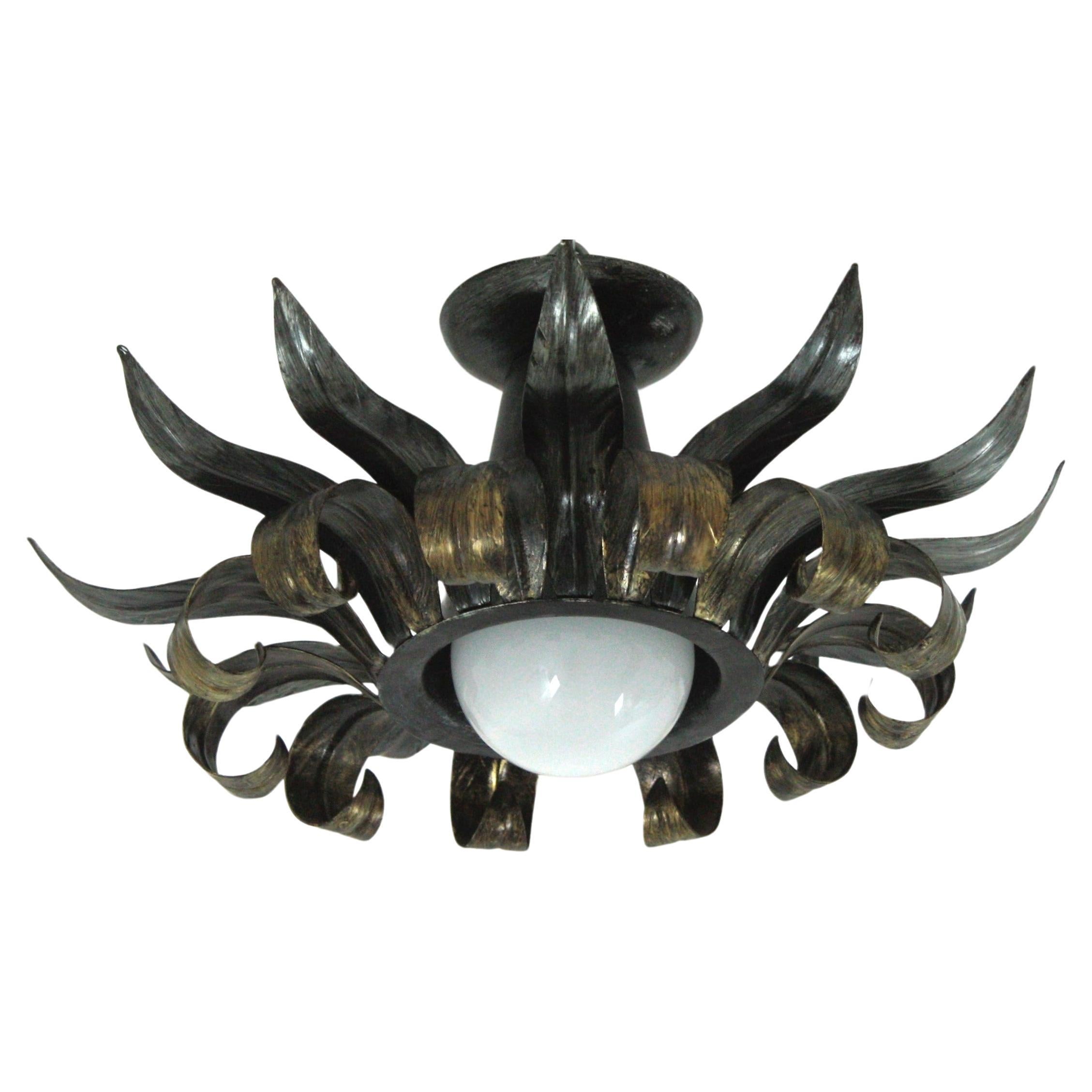 Brutalist silver and gilt patinated metal sunburst light fixture, France, 1950s.
Eye-catching iron sunburst flush mount with alternating rays in eye-lash shape. Patinated in silver color with golden accents. Nice aged patina and original finish.
It