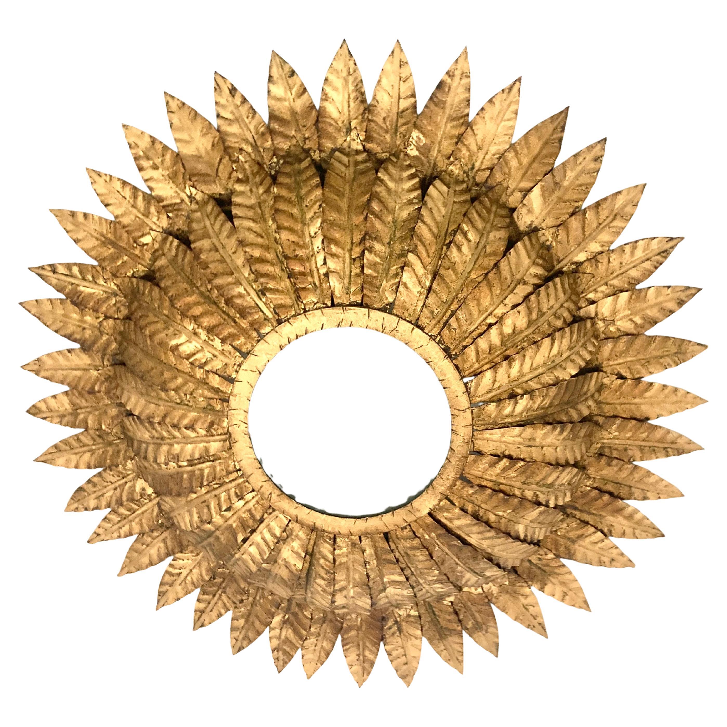 This large flush mount is composed of one layer of gilt metal leaves topped by a raised crown. The lens is frosted and in perfect condition. The light has 2 bulbs 40 watts each and it has been American wired, 
The lens allows the fixture to light a