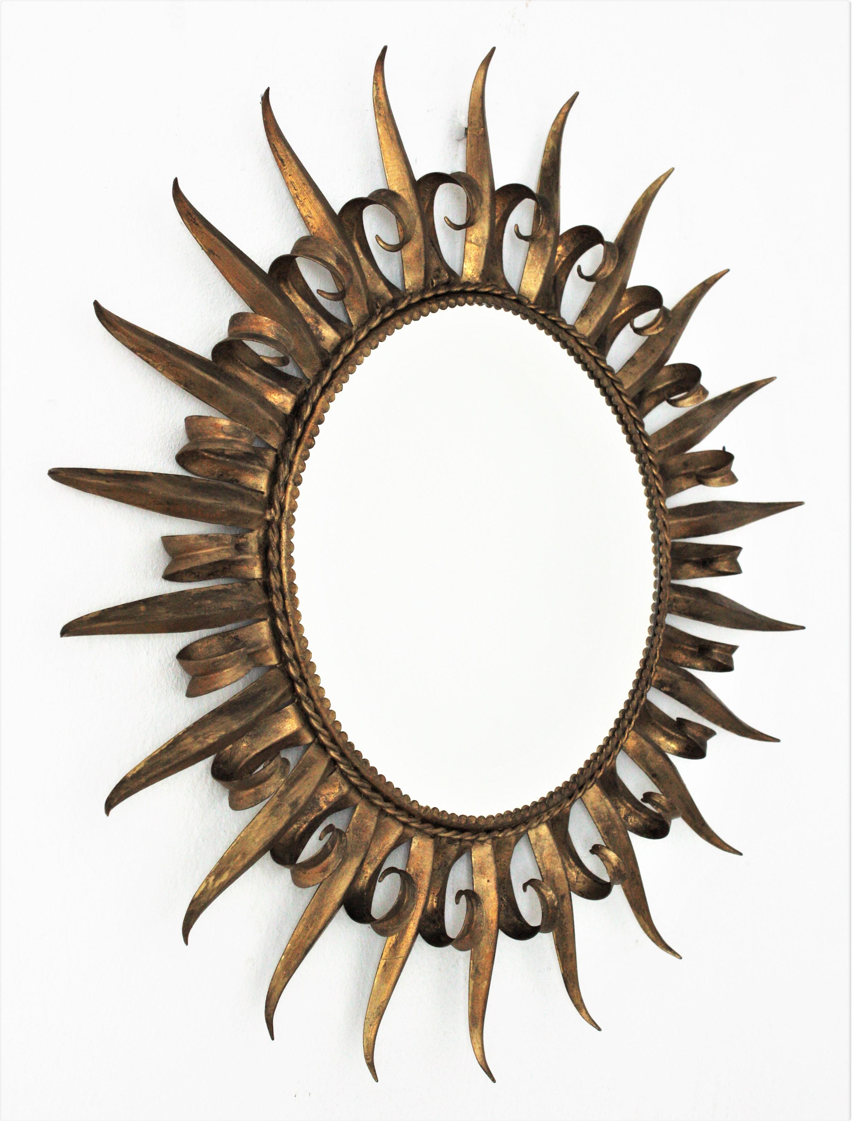 French gilt metal Brutalist eyelash circular mirror, circa 1950s.
Hand-hammered iron sunburst mirror with eyelash frame and a design combining midcentury and Brutalist accents. This wall mirror features an iron frame with alternating eyelash curved