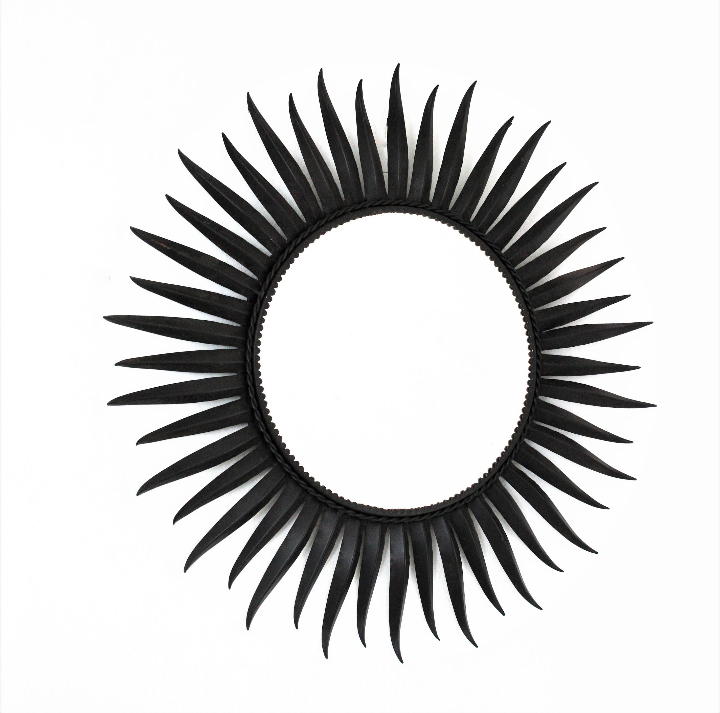 Eye-catching Eyelash round sunburst mirror in Iron, France, 1950s
The frame is made by a layer of beams with eyelash endings. 
The black color creates a strong visual effect. This sunburst mirror will be a nice addition to any Midcentury,