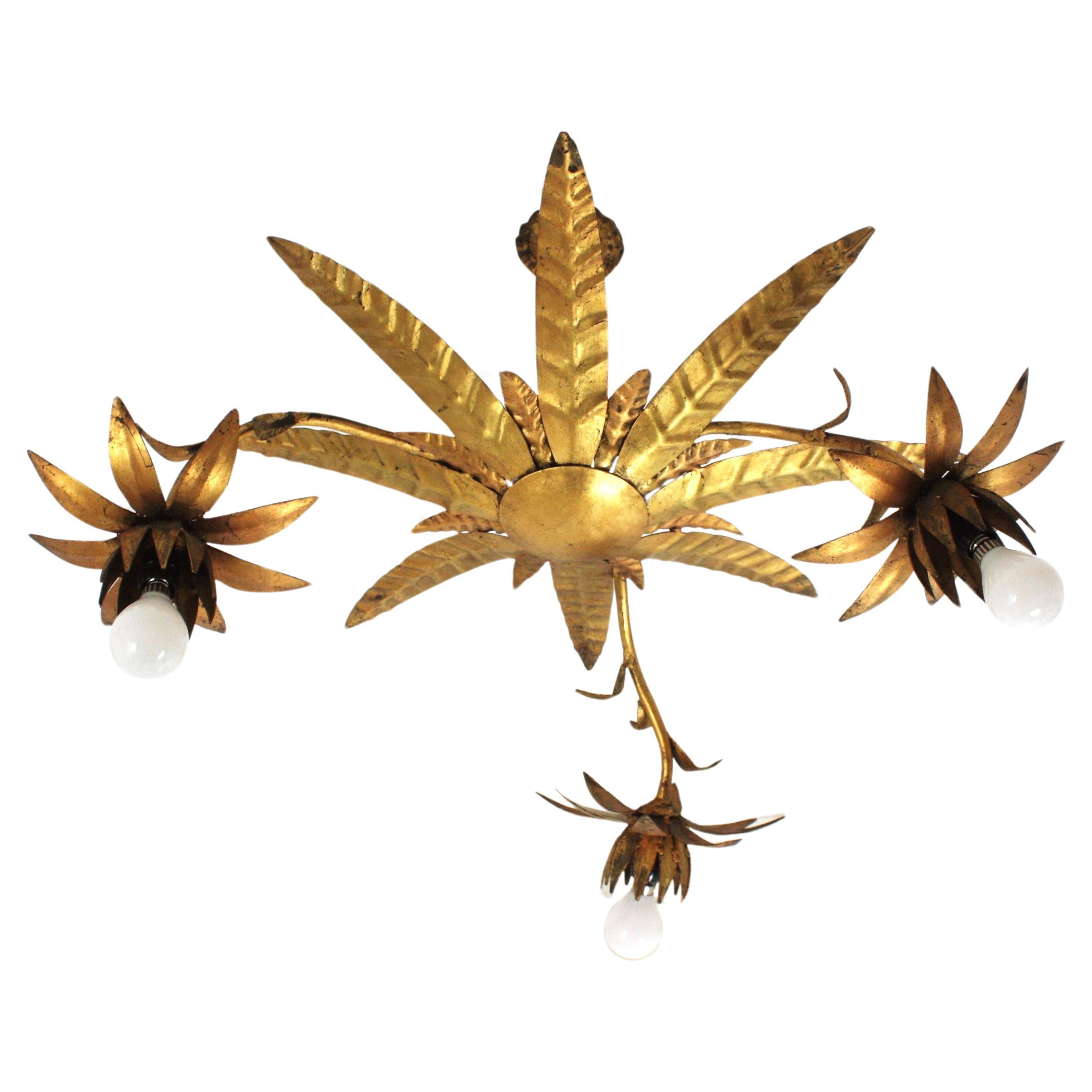 Outstanding sunburst foliage chandelier with three flowers, Gilt Iron. Spain, 1950s
This handcrafted ceiling lamp features a double layered leafed sunburst light fixture at the central part surrounded by three branches holding one flower each for 1