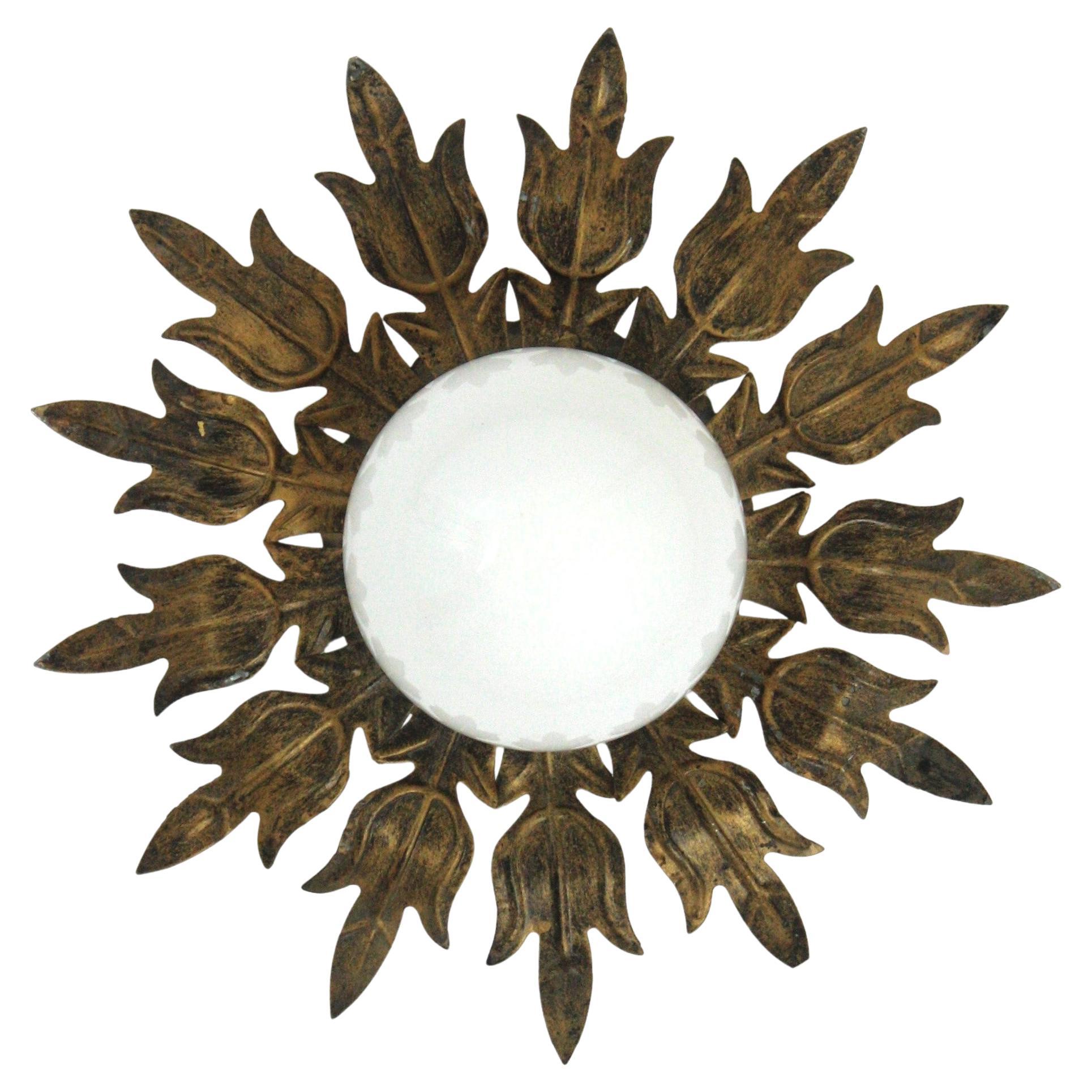 Spanish Gilt Iron Flower Foliage Sunburst Light with Milk Glass Globe 
___________________________________________________________
Eye-catching flower sunburst flush mount in gilt iron and milk glass, 1950s
This Sunburst flower ceiling light fixture