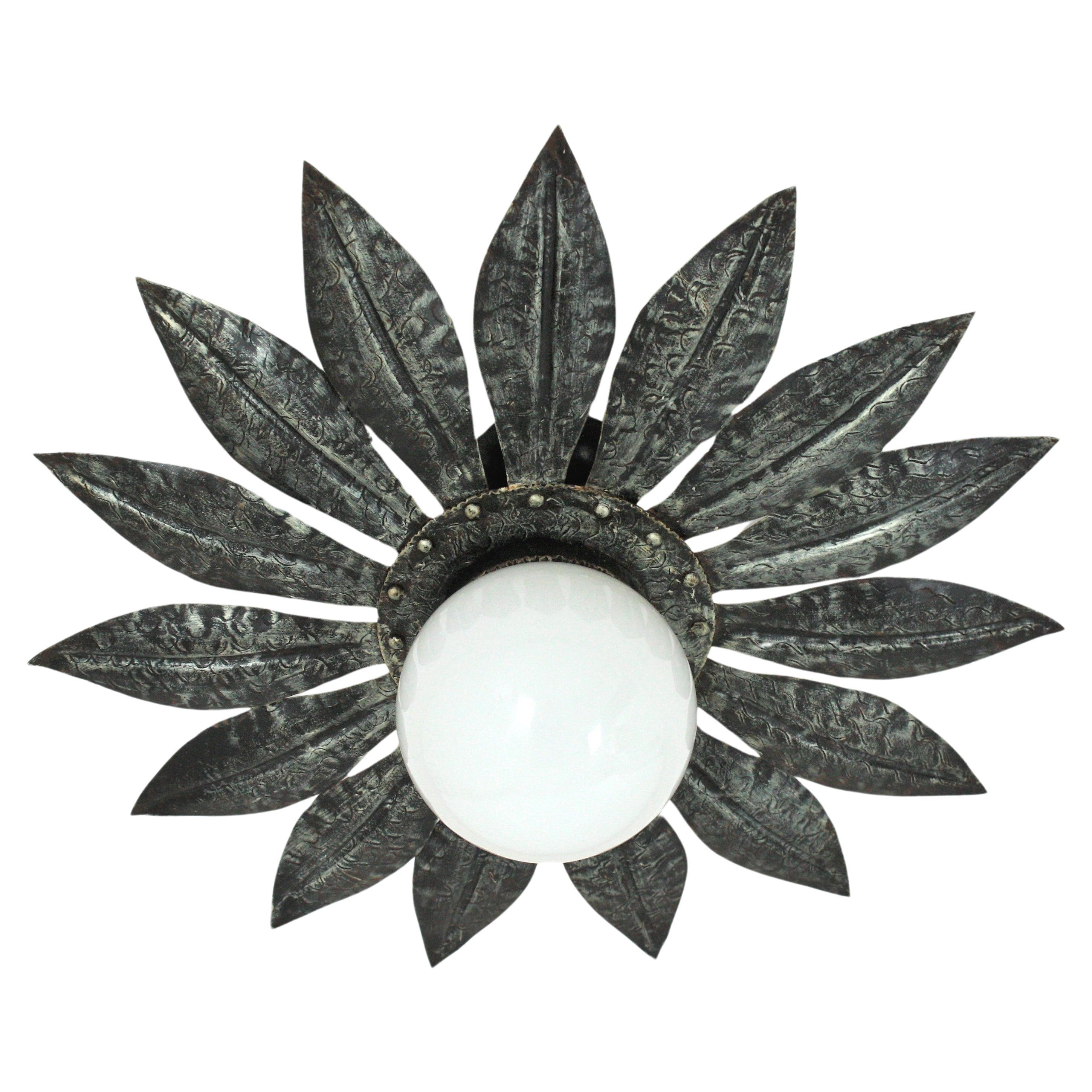 Flower Sunburst Silvered Ceiling Light Fixture
Eye-catching Midcentury flower or sunburst ceiling lamp, silvered metal, milk glass. Spain, 1950s-1960s.
This flush mount features a flower burst or sunburst in silver color with leaves surrounding a