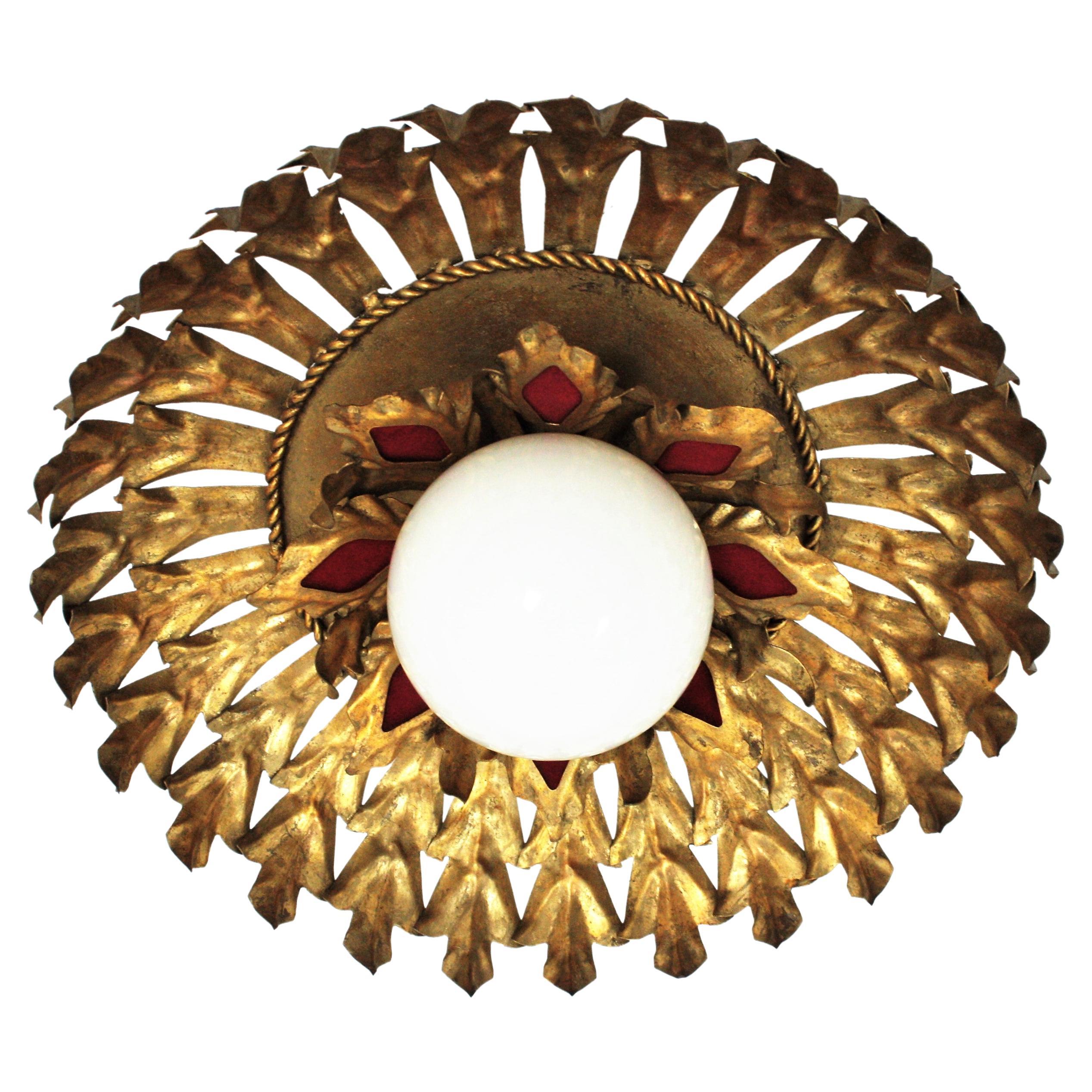 Llamativo aplique de luz solar con diseño de follaje y pantalla de globo de cristal de leche, España, años 50
Este empotrable de techo tiene dos capas de hojas de hierro dorado que rodean una pantalla central en forma de globo de cristal opalino.