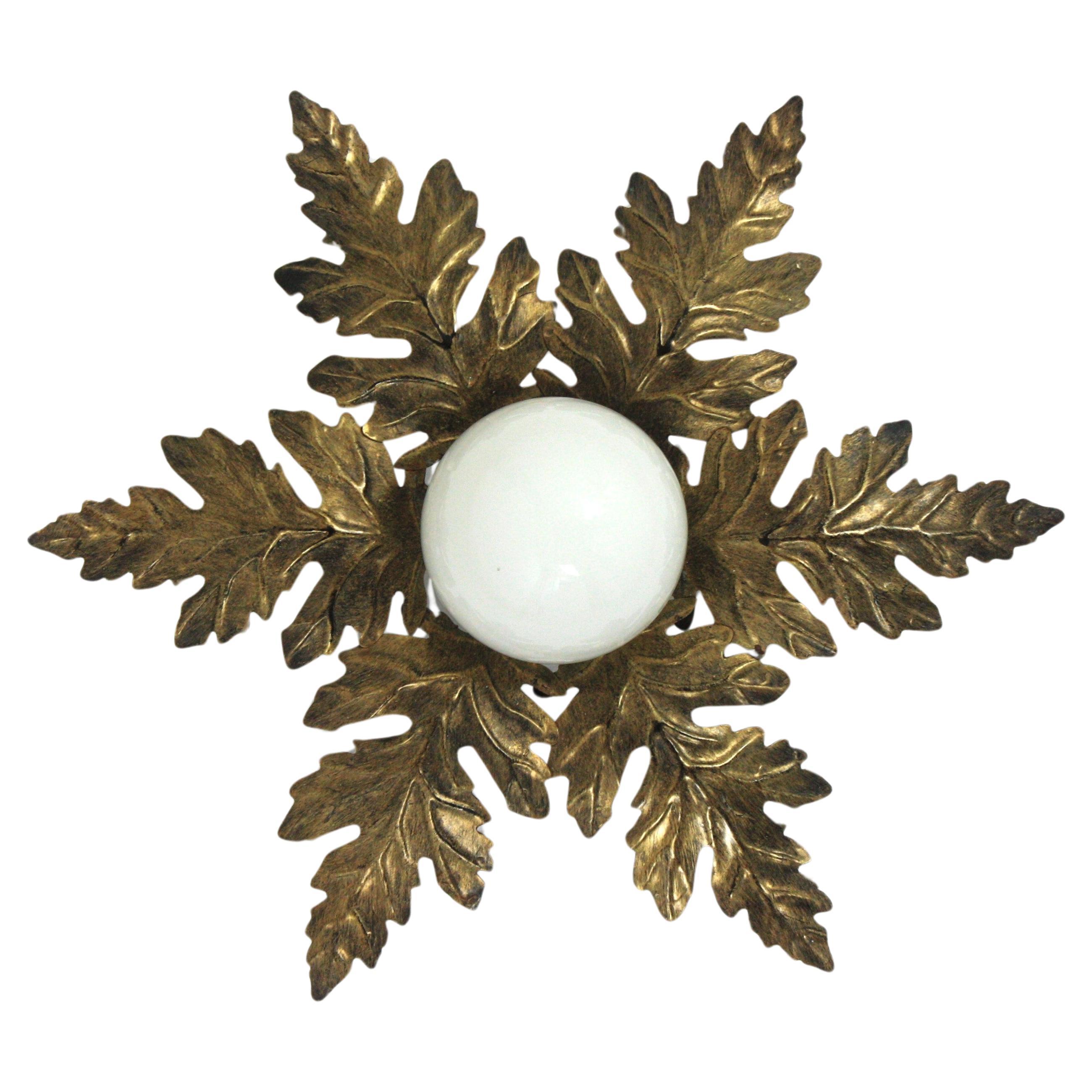 Beautiful gilt iron flush mount light fixture with glass globe shade and foliage frame. Manufactured by Ferro Art, Spain, 1960s.
This lovely ceiling light has a nice design with leaves surrounding a central opaline glass globe.
A cool ceiling lamp